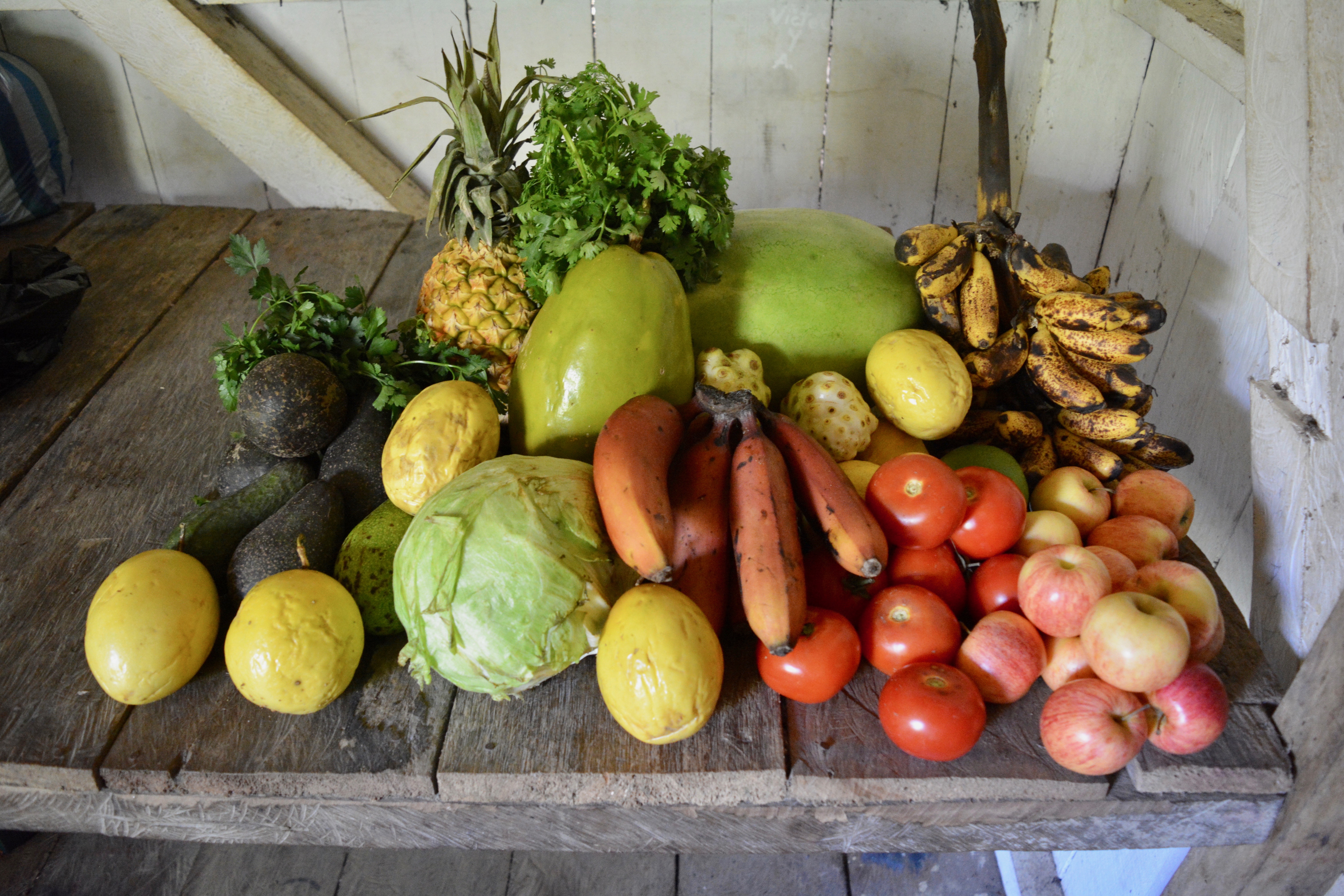 Colorful assortment of fresh fruits and vegetables on rustic wooden table.