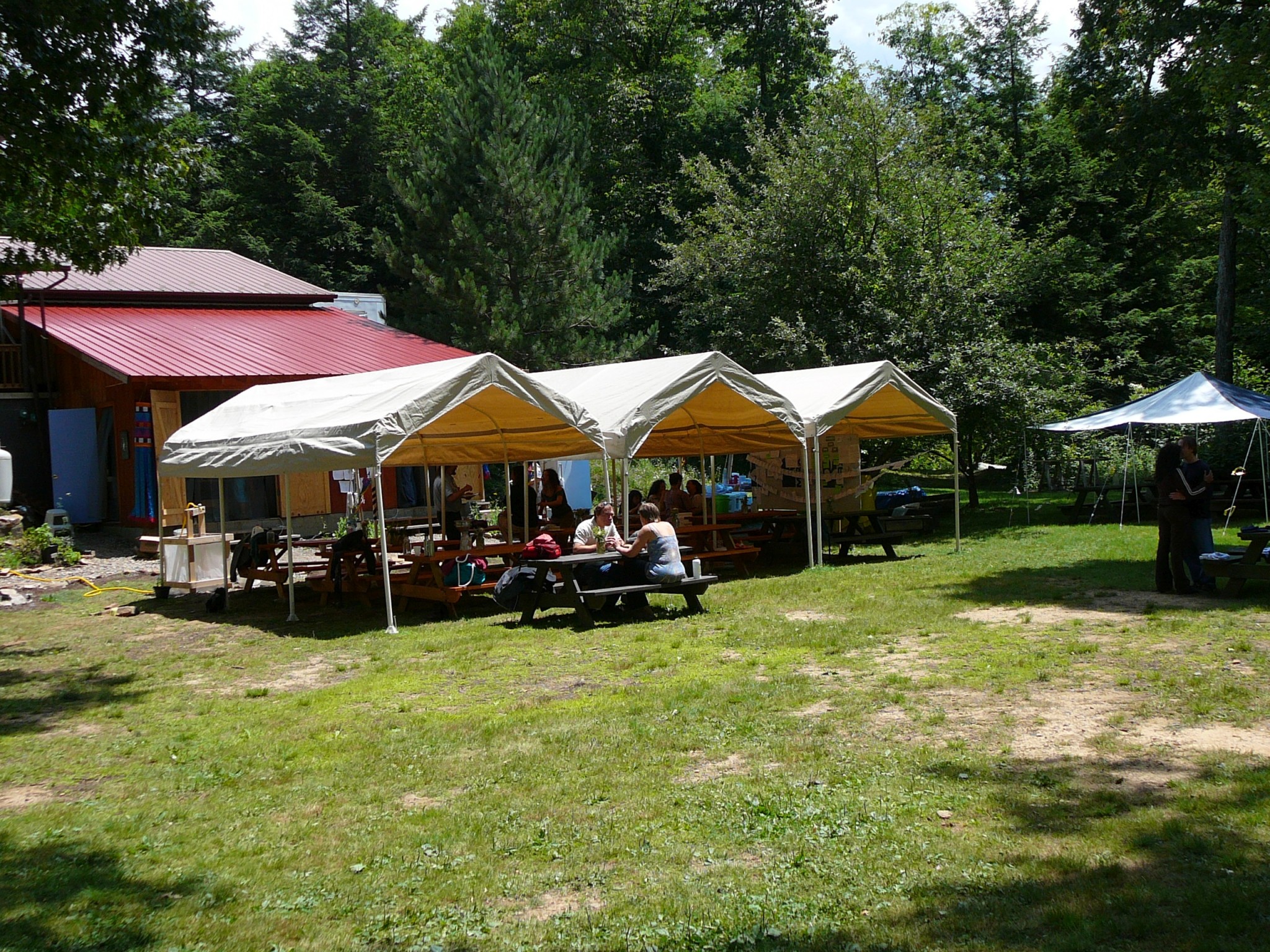 Outdoor community event with tents and people at Allegheny Crest.