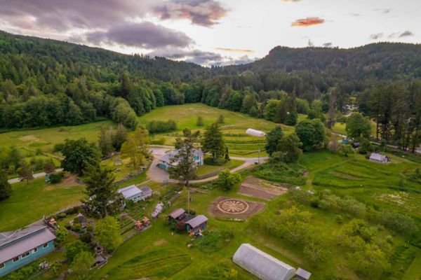Aerial view of Salt Spring Centre of Yoga with lush greenery and rolling hills.