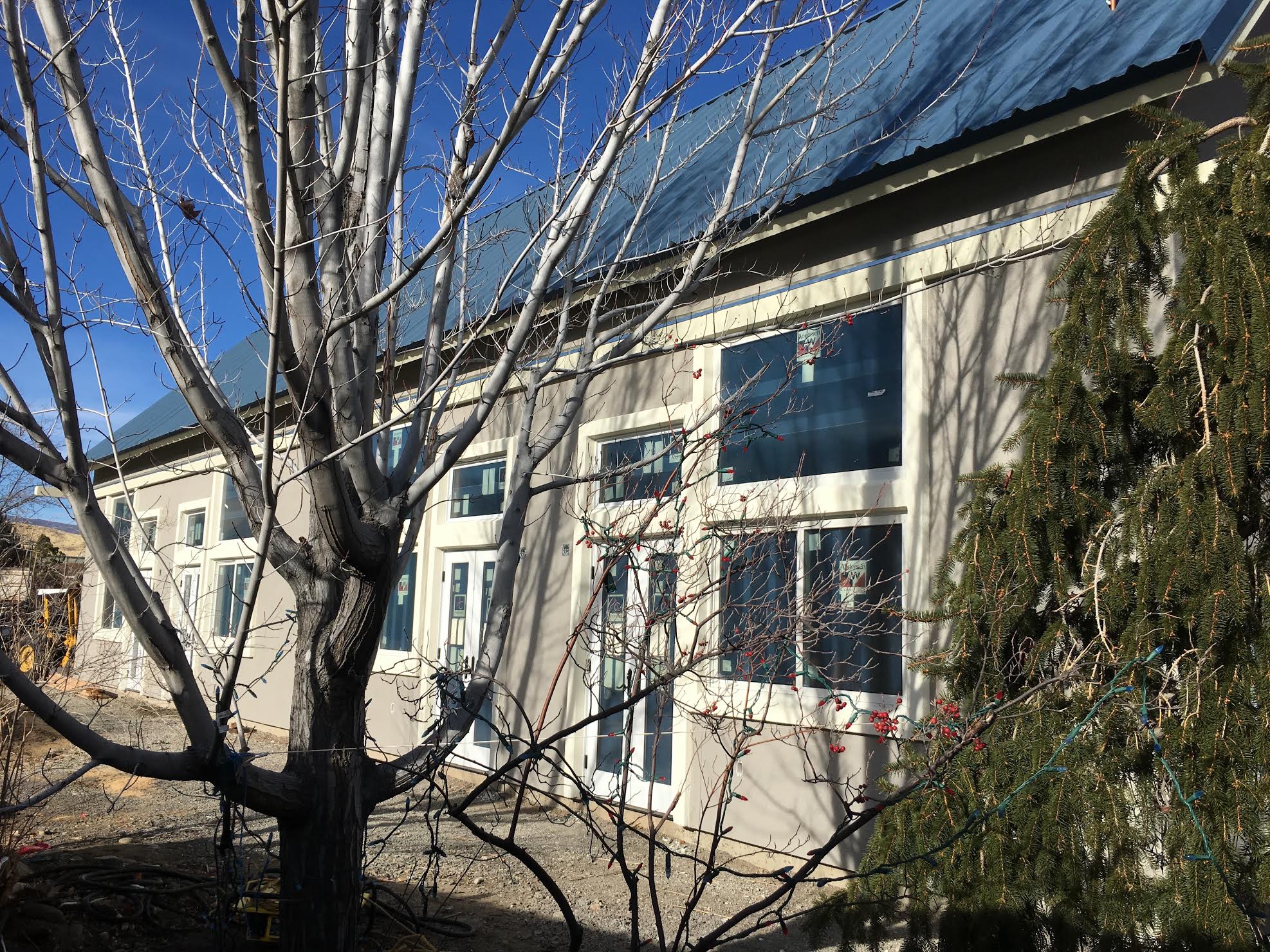 Community building at Dancing River Community LLC with trees and clear sky.