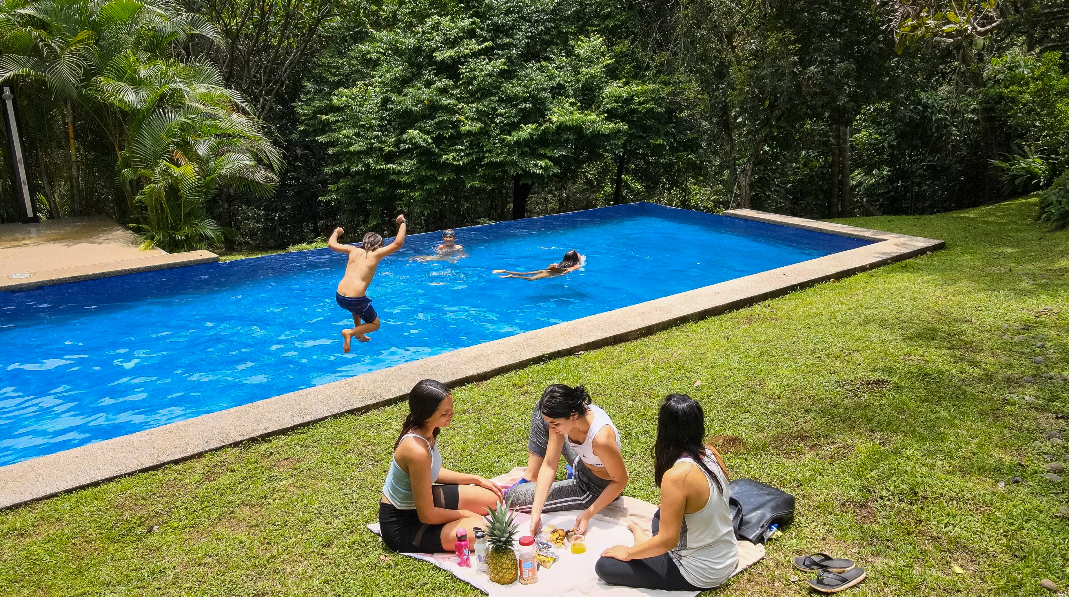 People enjoying a community pool at La Ecovilla Costa Rica.