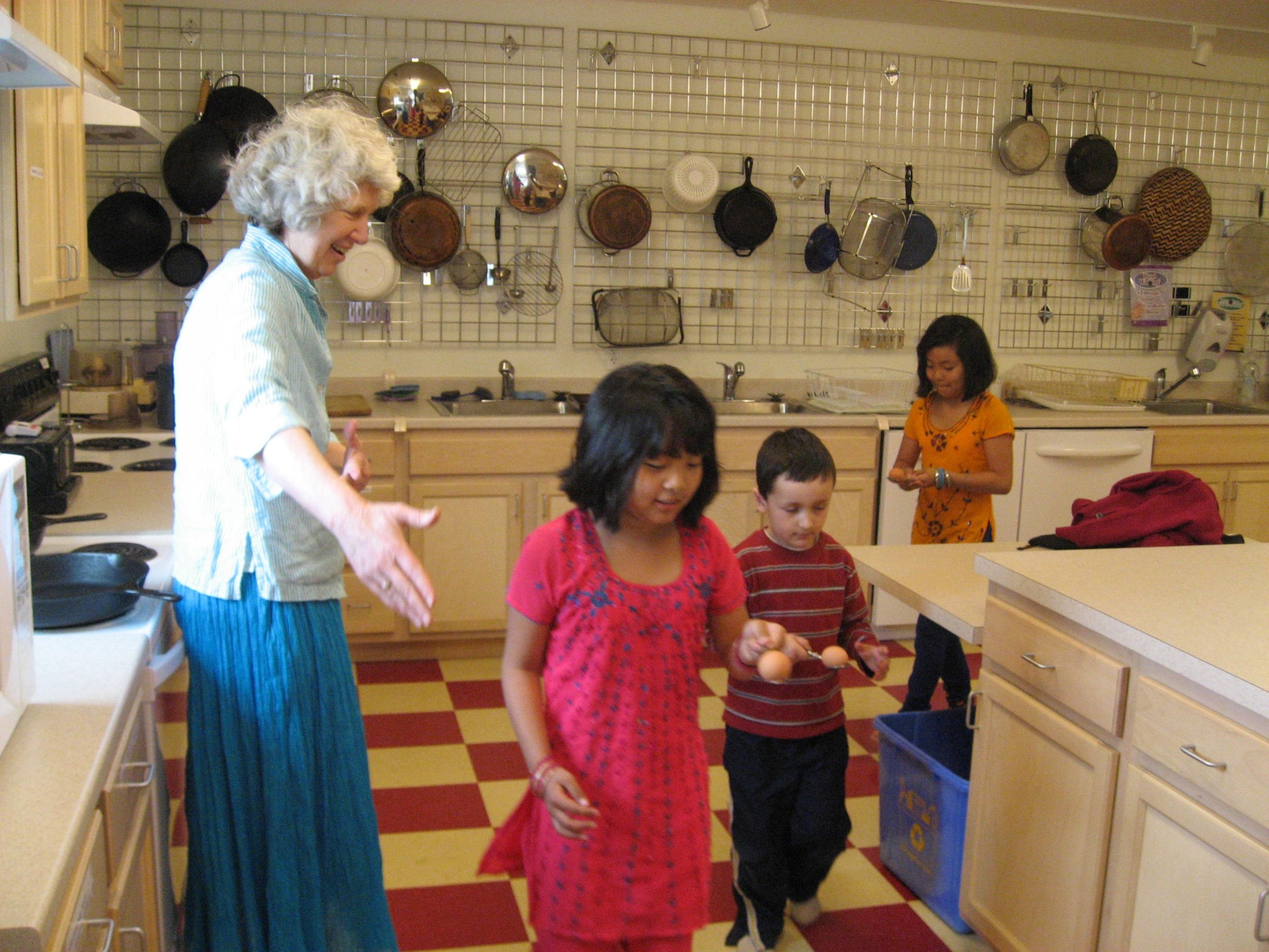 Group of children and an adult in a community kitchen setting.
