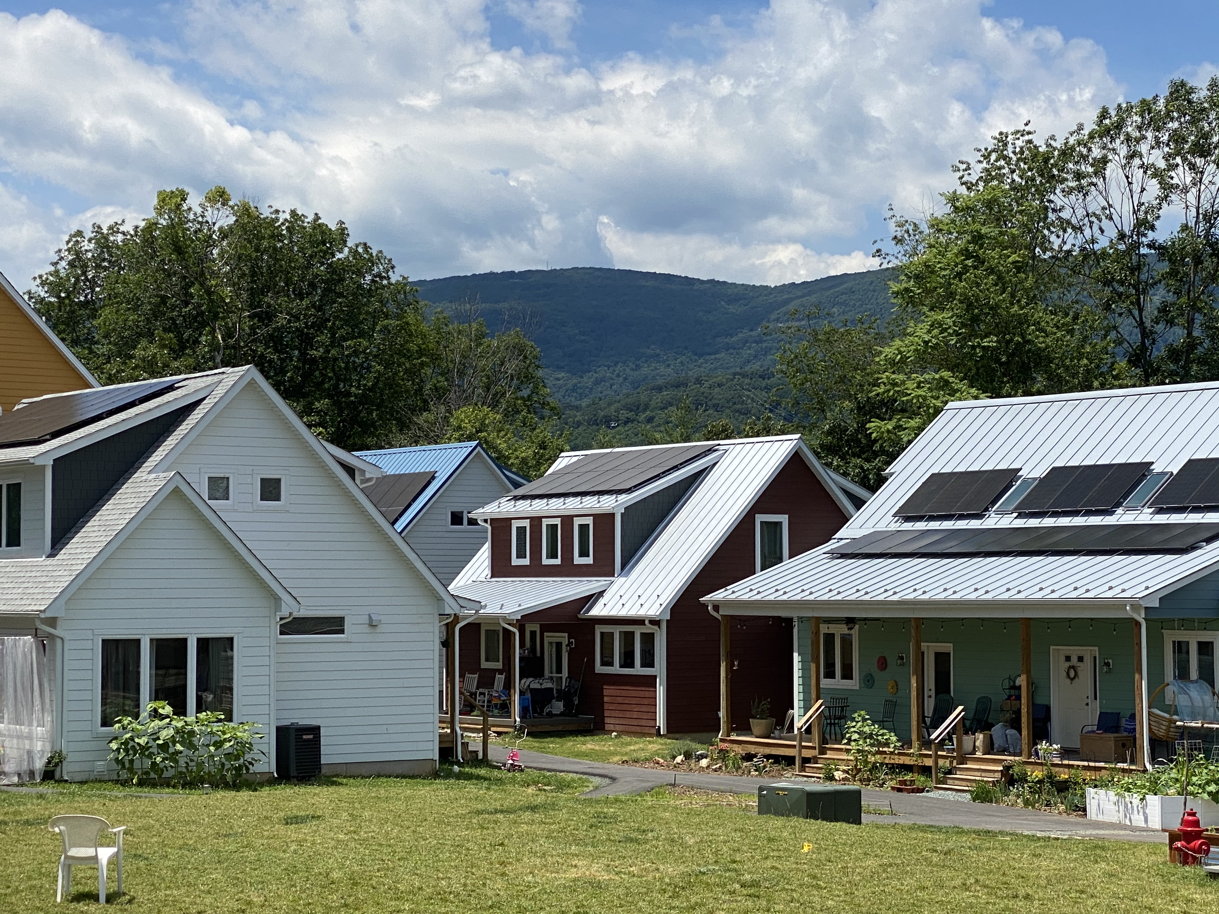 Colorful cohousing homes with solar panels and mountain view.