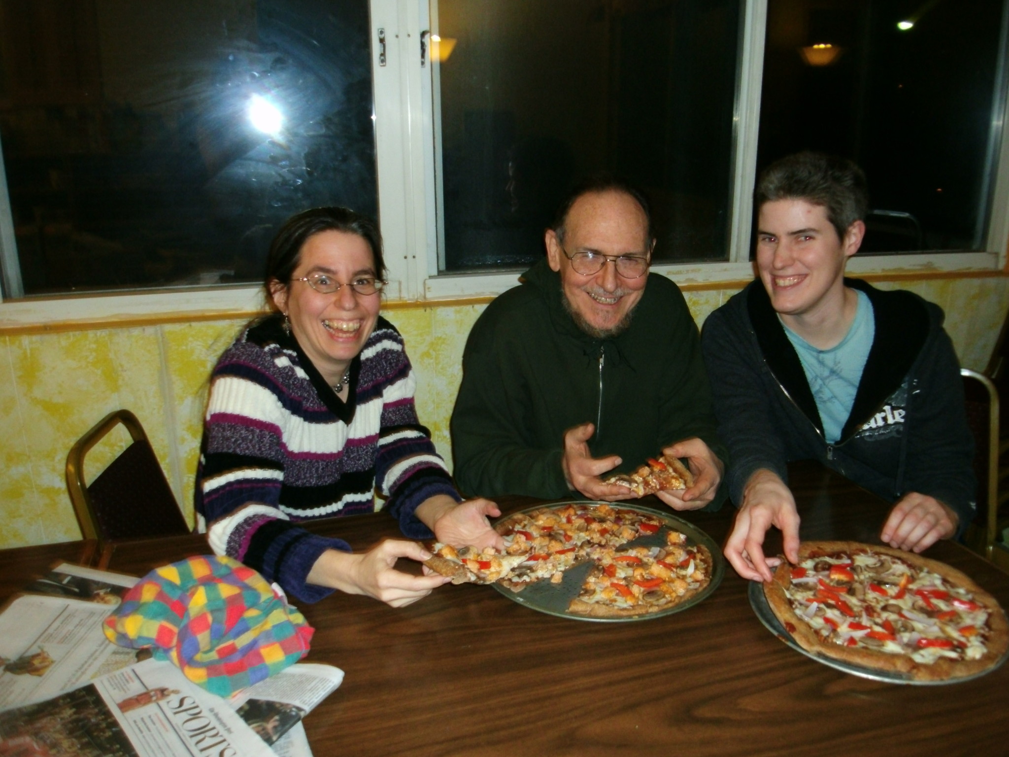 People sharing pizza at a community gathering in Chrysalis Community.