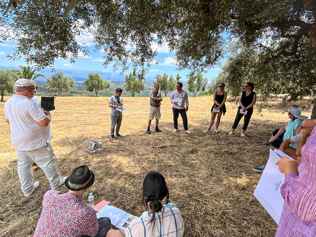 Group of people participating in outdoor community meeting in Greece.