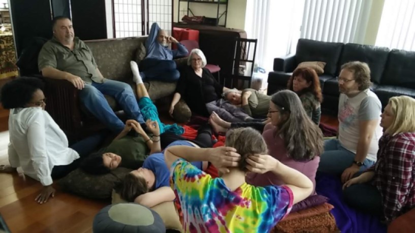Group of people sitting and talking in a cozy living room setting.