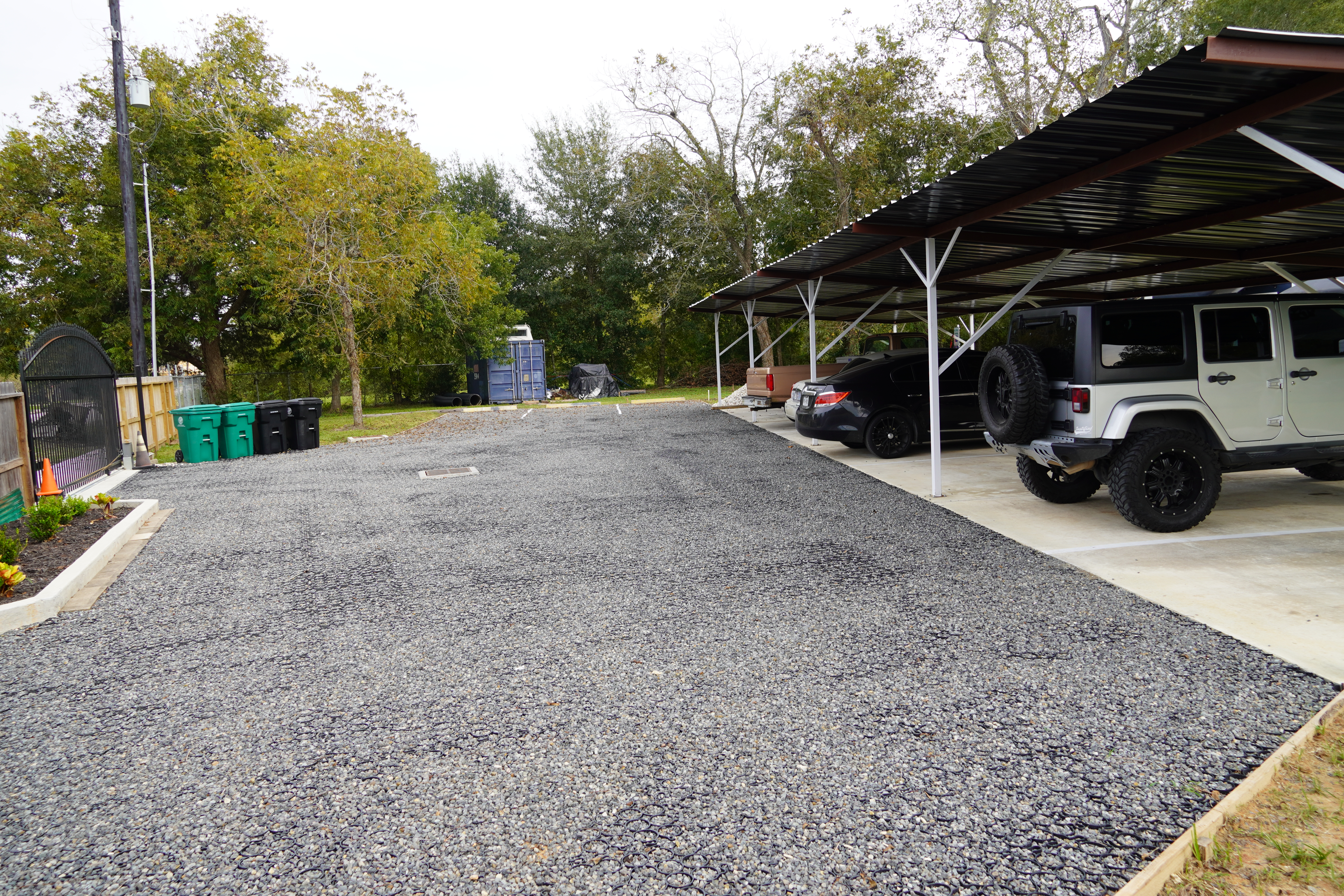 Parking lot with covered parking and vehicles at Foundation for Intentional Community.