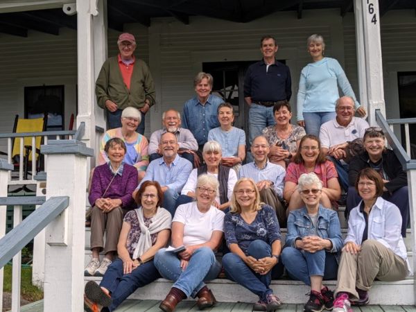 Group of diverse people smiling on porch at Hager Homestead.