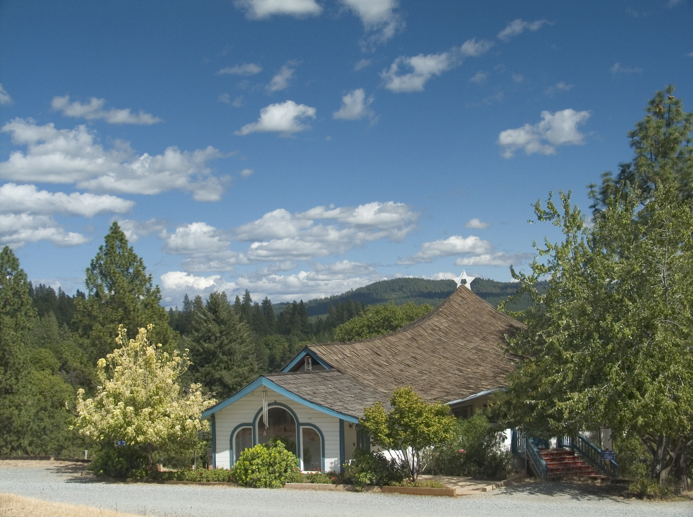 Scenic view of blue sky with white clouds and green trees.