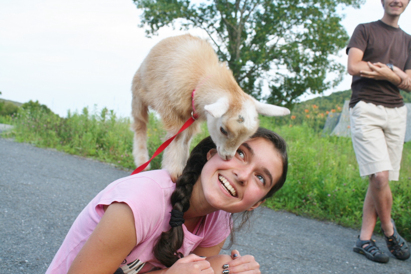 Woman with a dog on her head in a rural community setting.