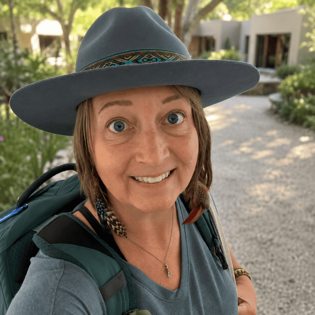 Woman smiling with hat at intentional community event or gathering.