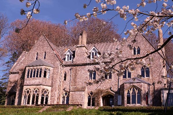 Gothic Revival house with pointed arches and large windows in springtime.