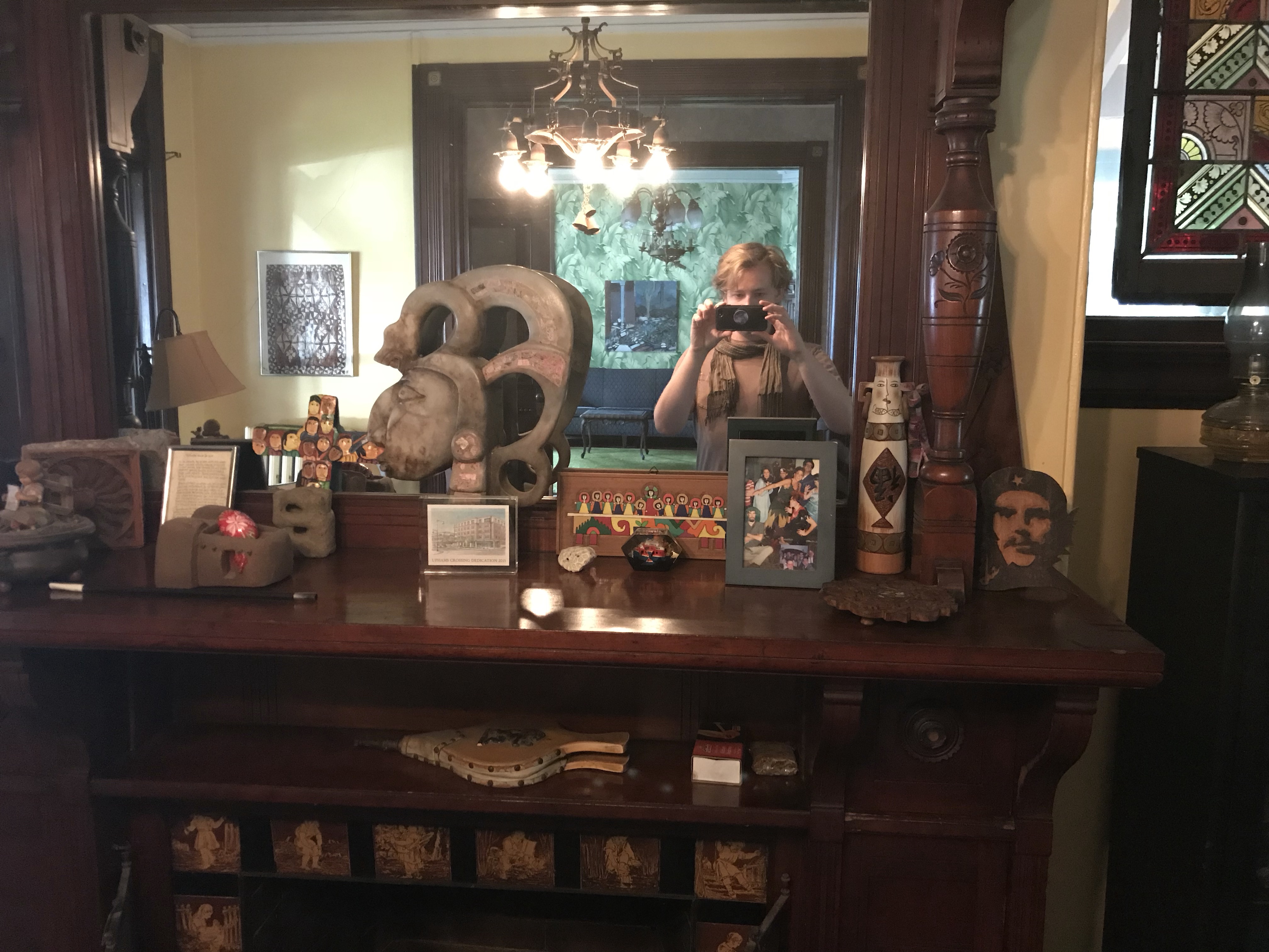 Decorative wooden sideboard with artifacts and a mirror reflection.