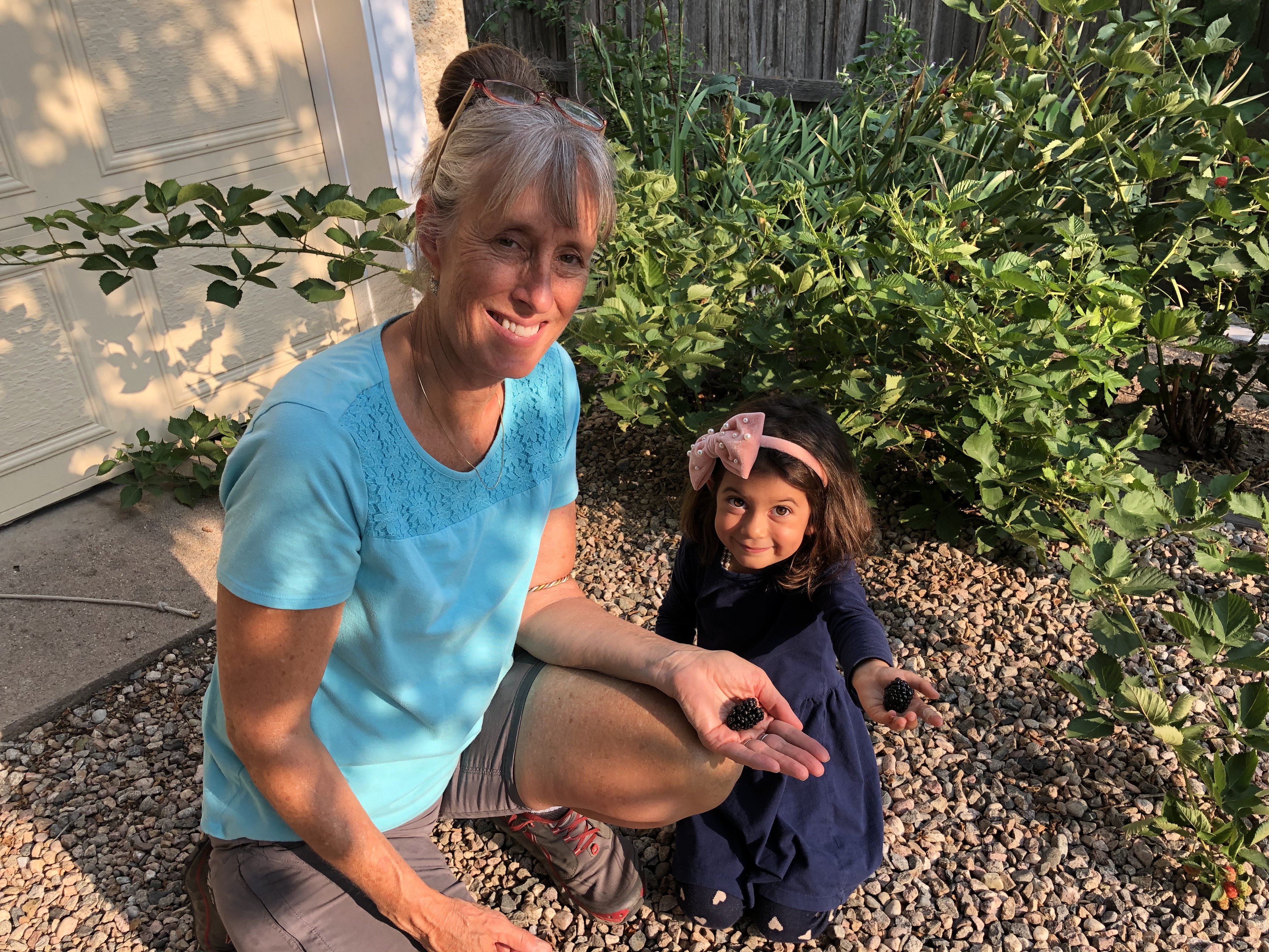 Woman and young girl planting seeds in a garden at Polestar Village.