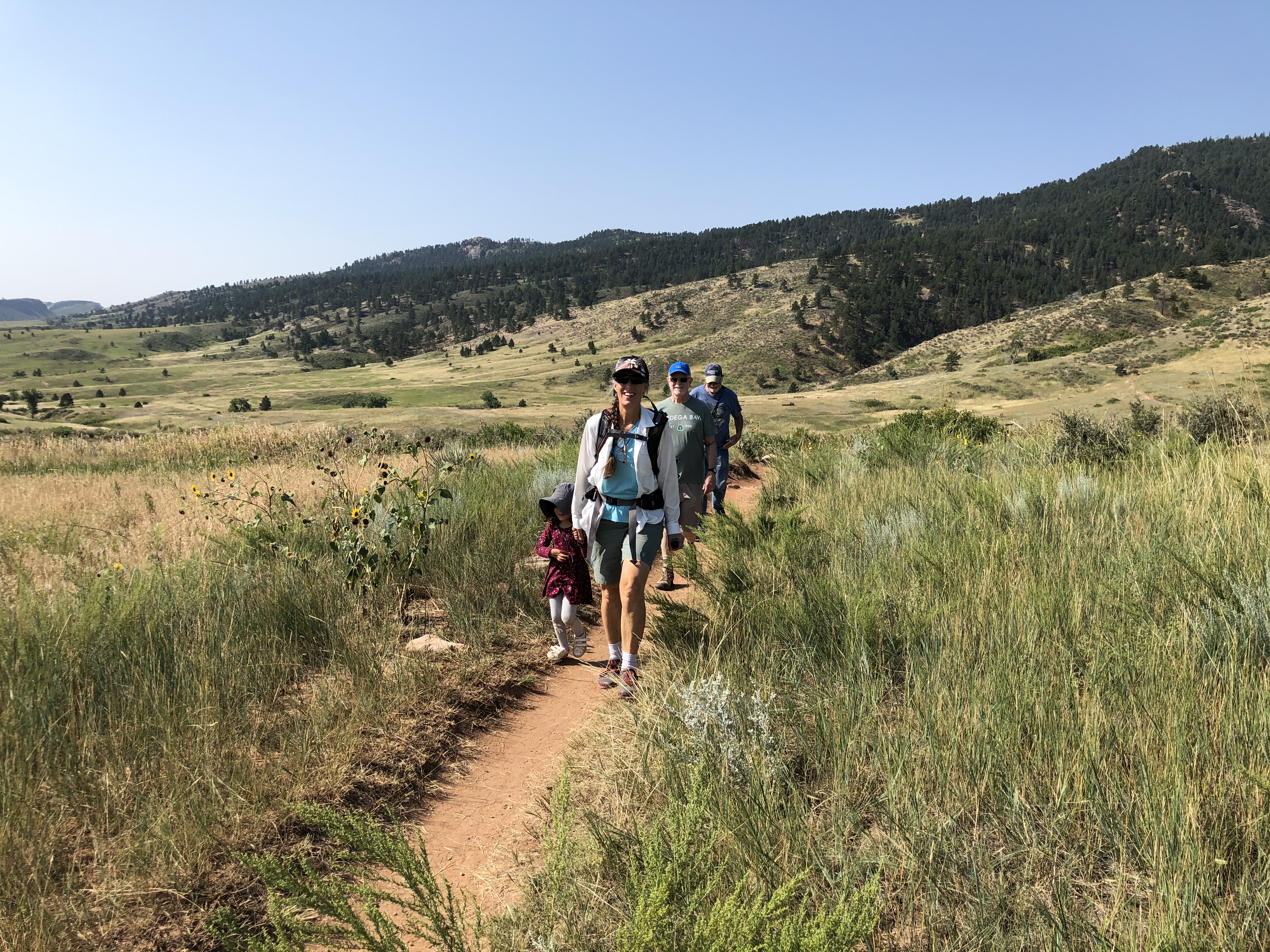 Group of people hiking on a trail in a scenic landscape near Polestar Village.