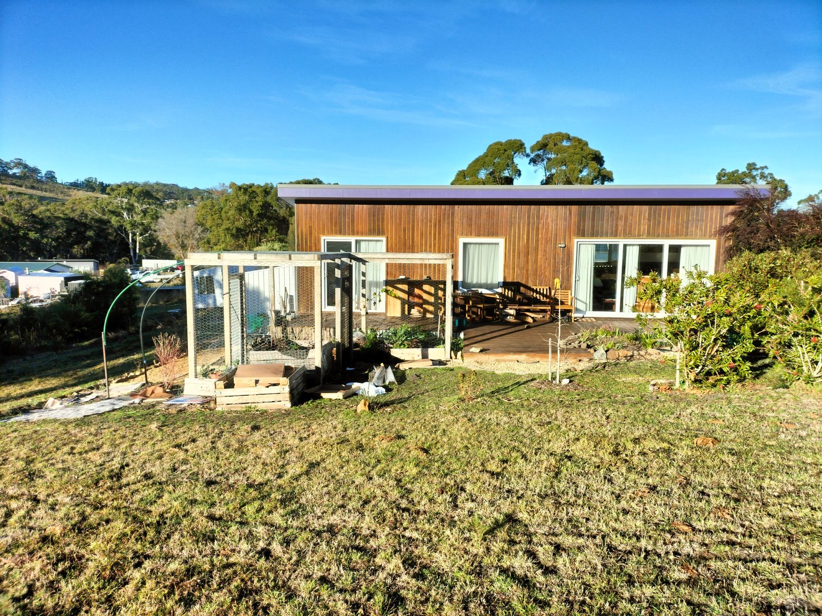 Eco-friendly community building at Tasman Ecovillage with garden and solar panels.