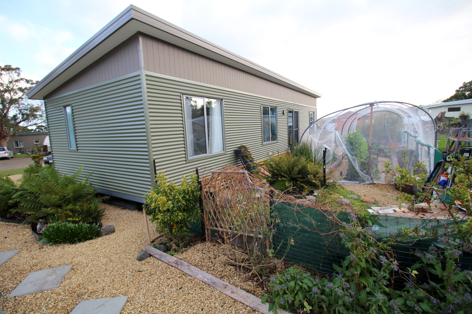 Eco-friendly house at Tasman Ecovillage with garden and greenhouse.