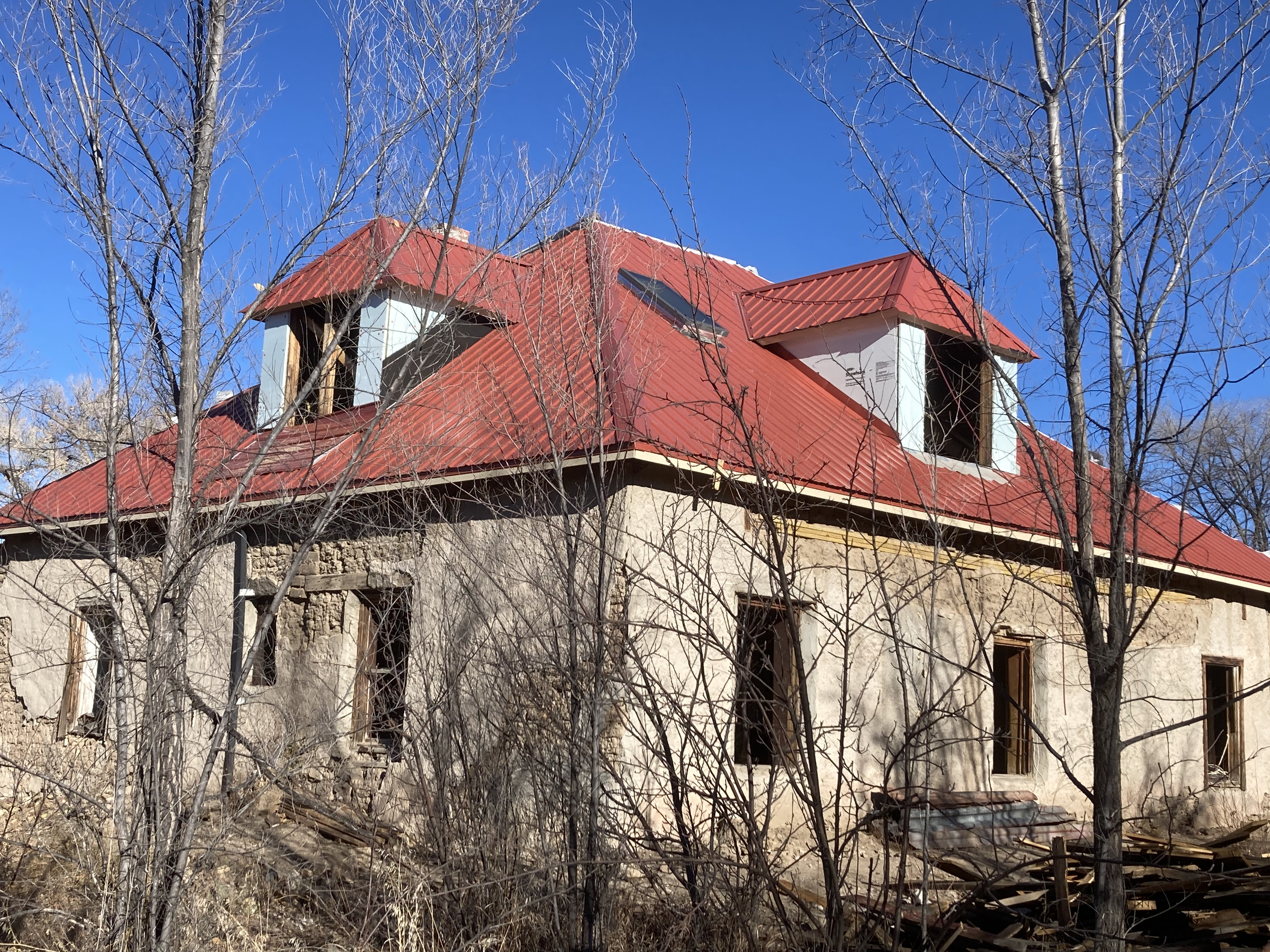 Eco-friendly house with red roof in a wooded area.