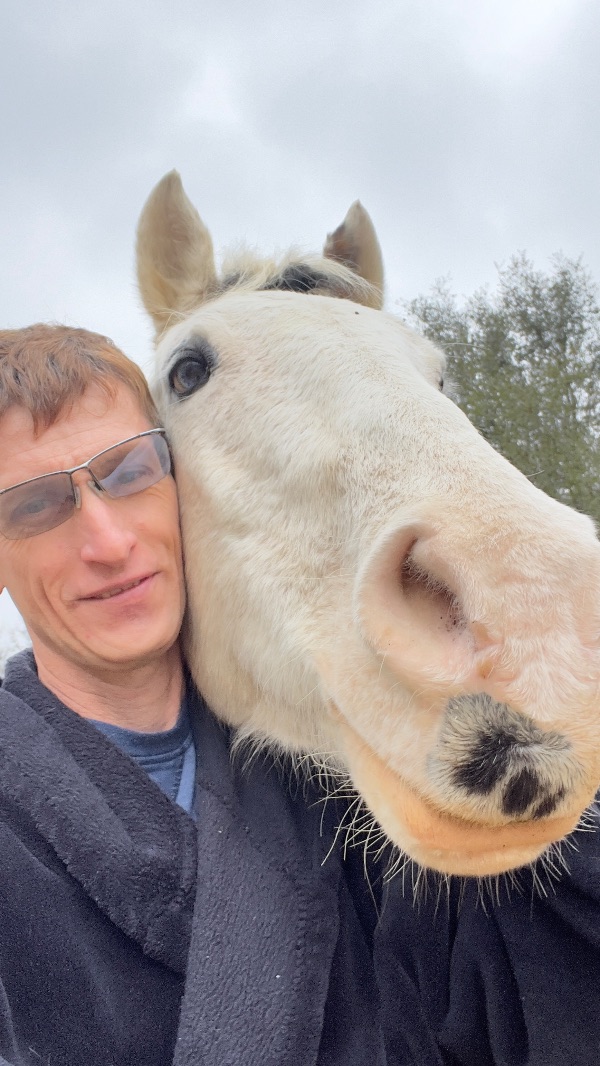 Close-up of a person with a white horse at Camp Ikigai Animal Sanctuary.