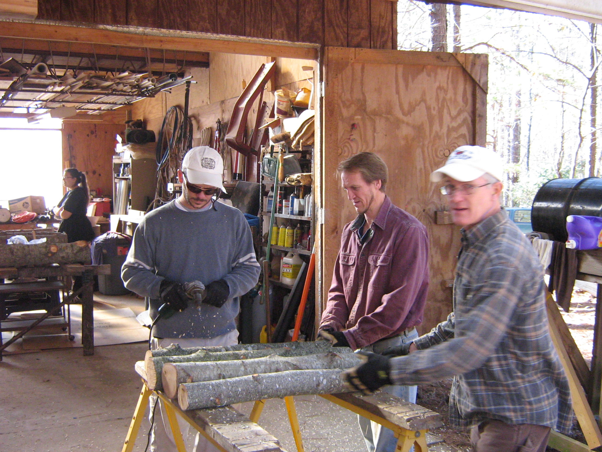 People working together on a woodworking project outdoors at a community space.