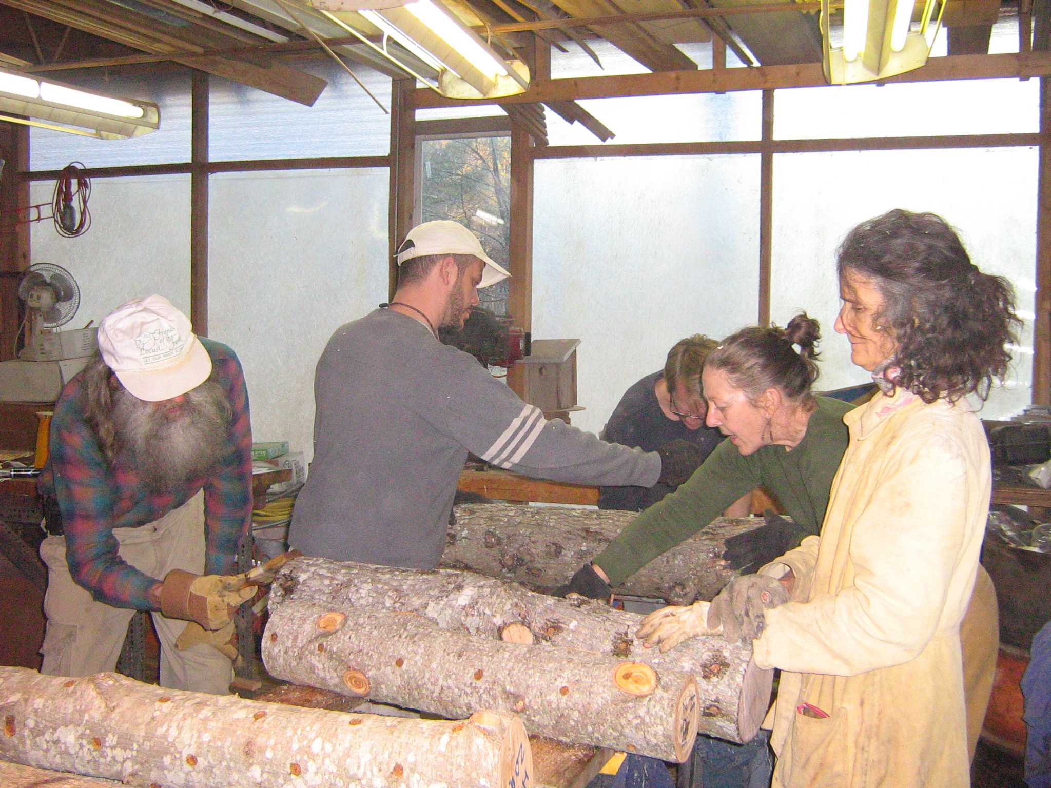 Group of people working together on a woodworking project in a community space.