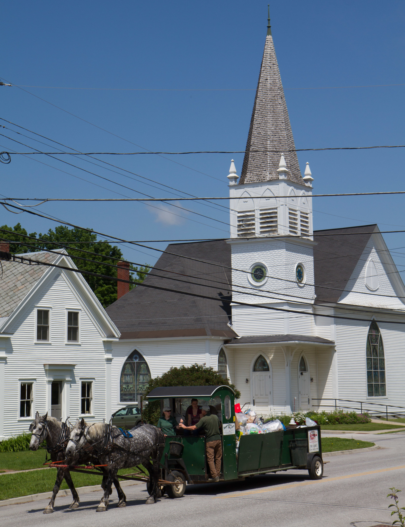 Historic church with horse-drawn carriage in front, community setting.