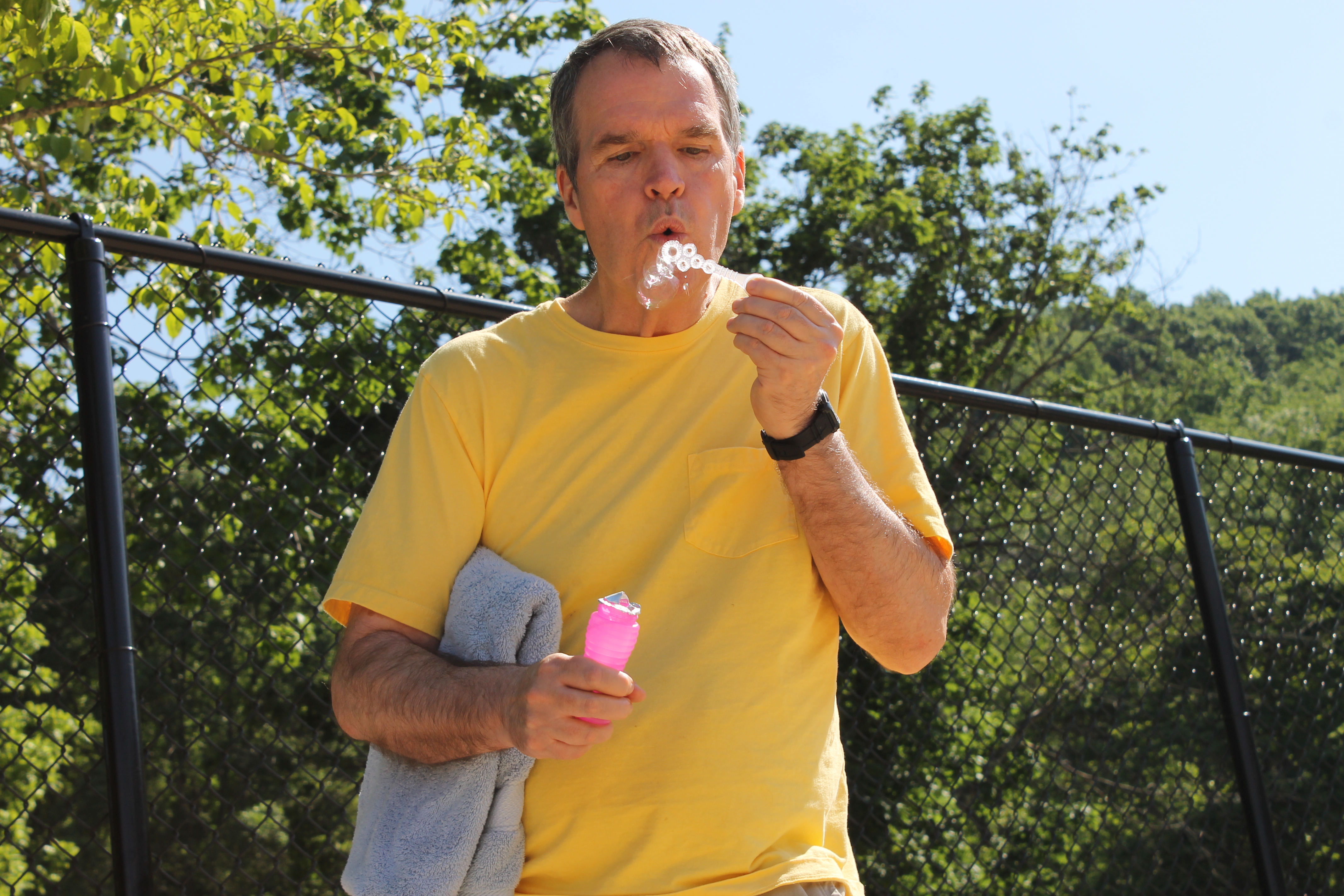 Man in yellow shirt enjoying a snack outdoors at Innisfree Village.