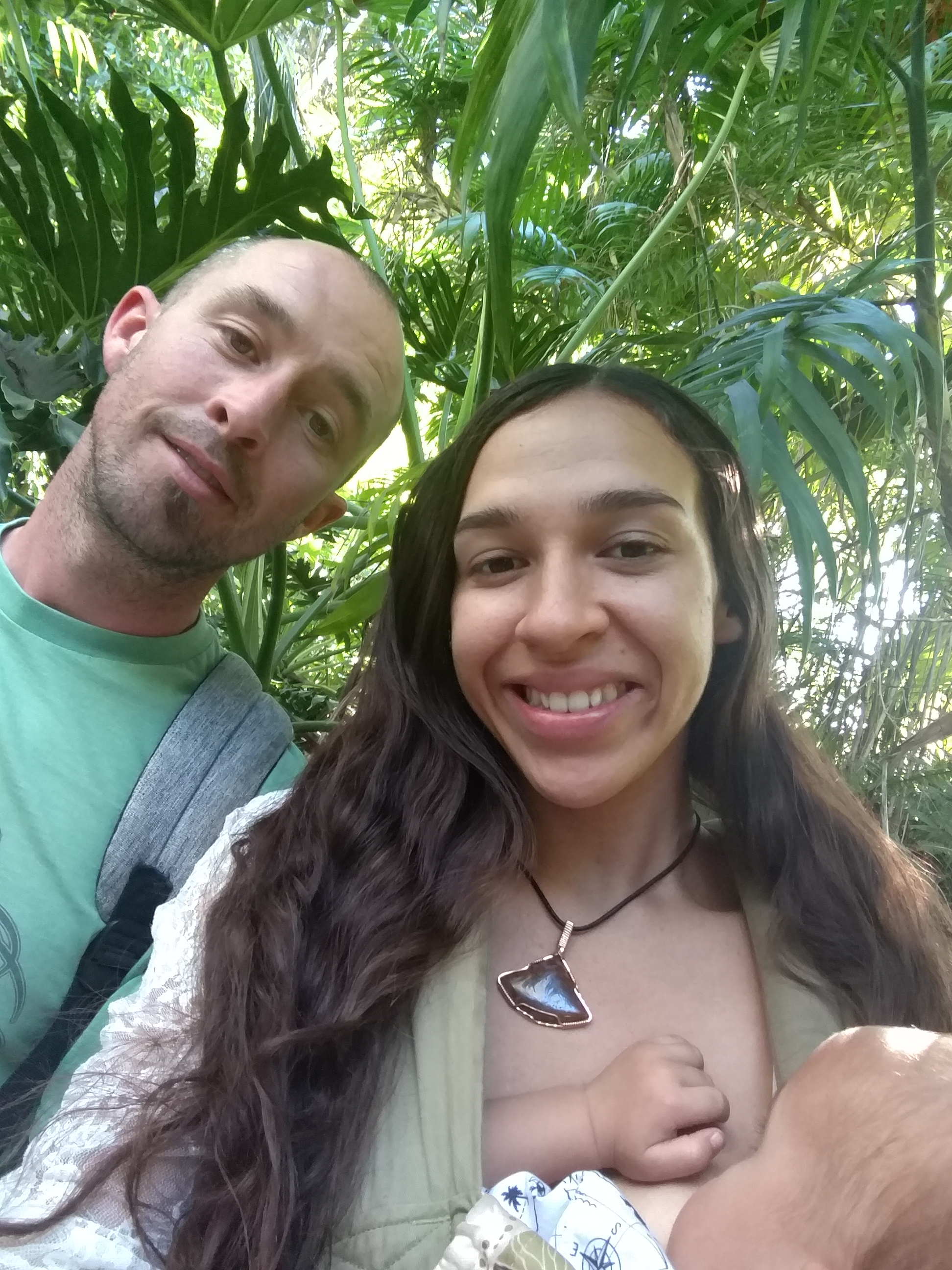Smiling couple in lush green jungle for Roots to Heal Farmacy post.