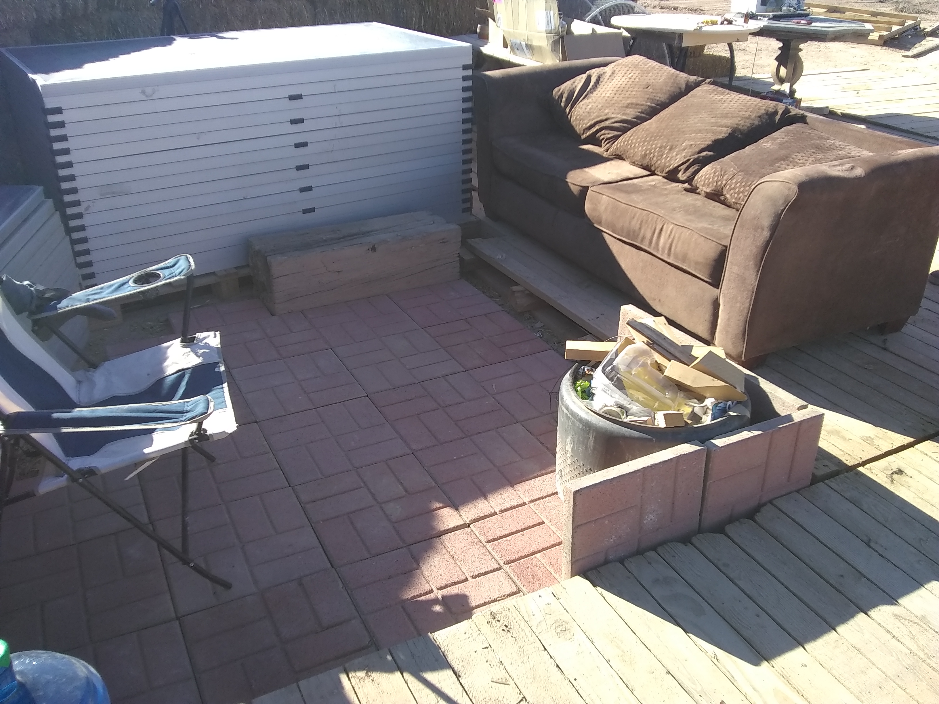 Outdoor patio with sofa, chairs, and decorative elements.