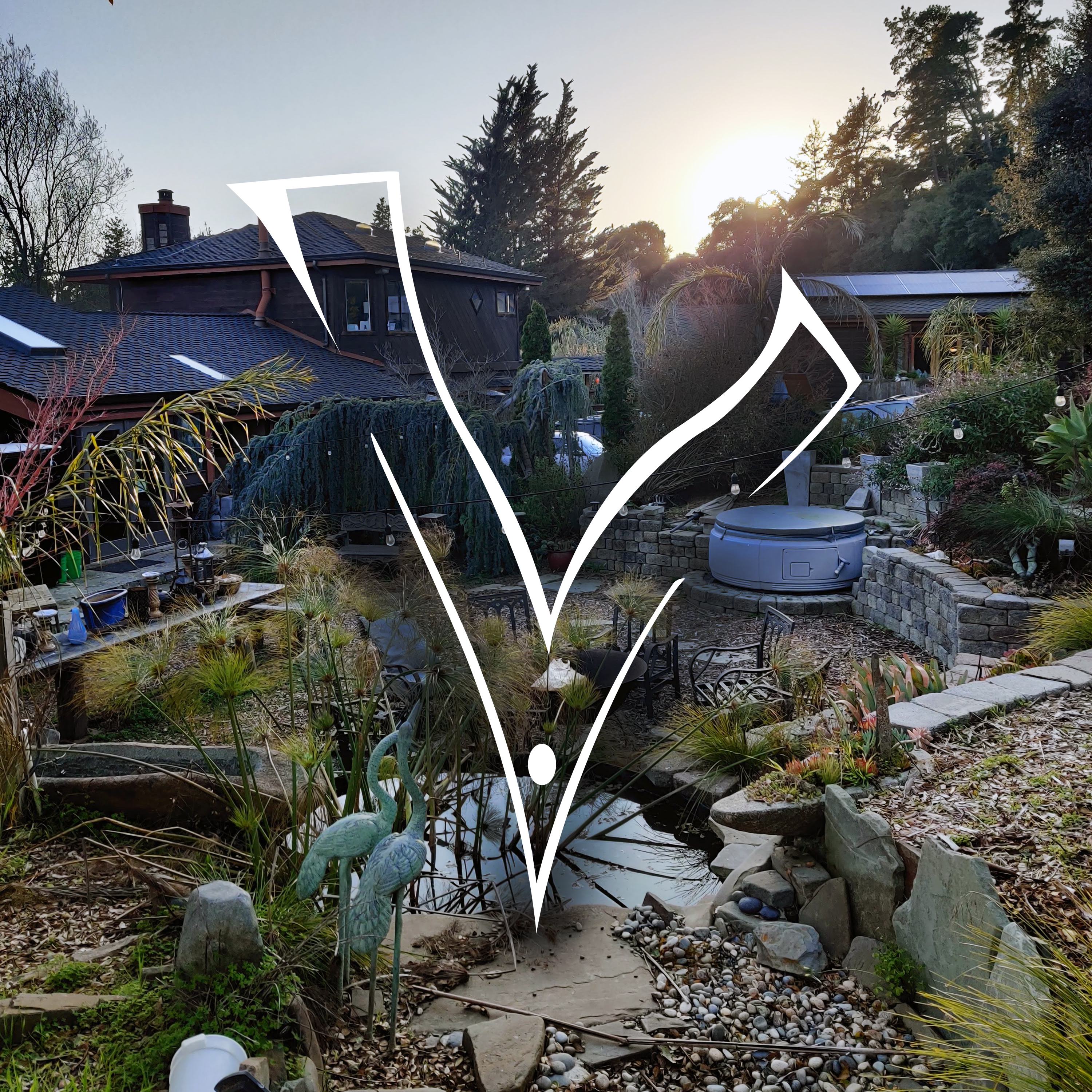 Community garden with pond, plants, and seating at Foundation for Intentional Community.