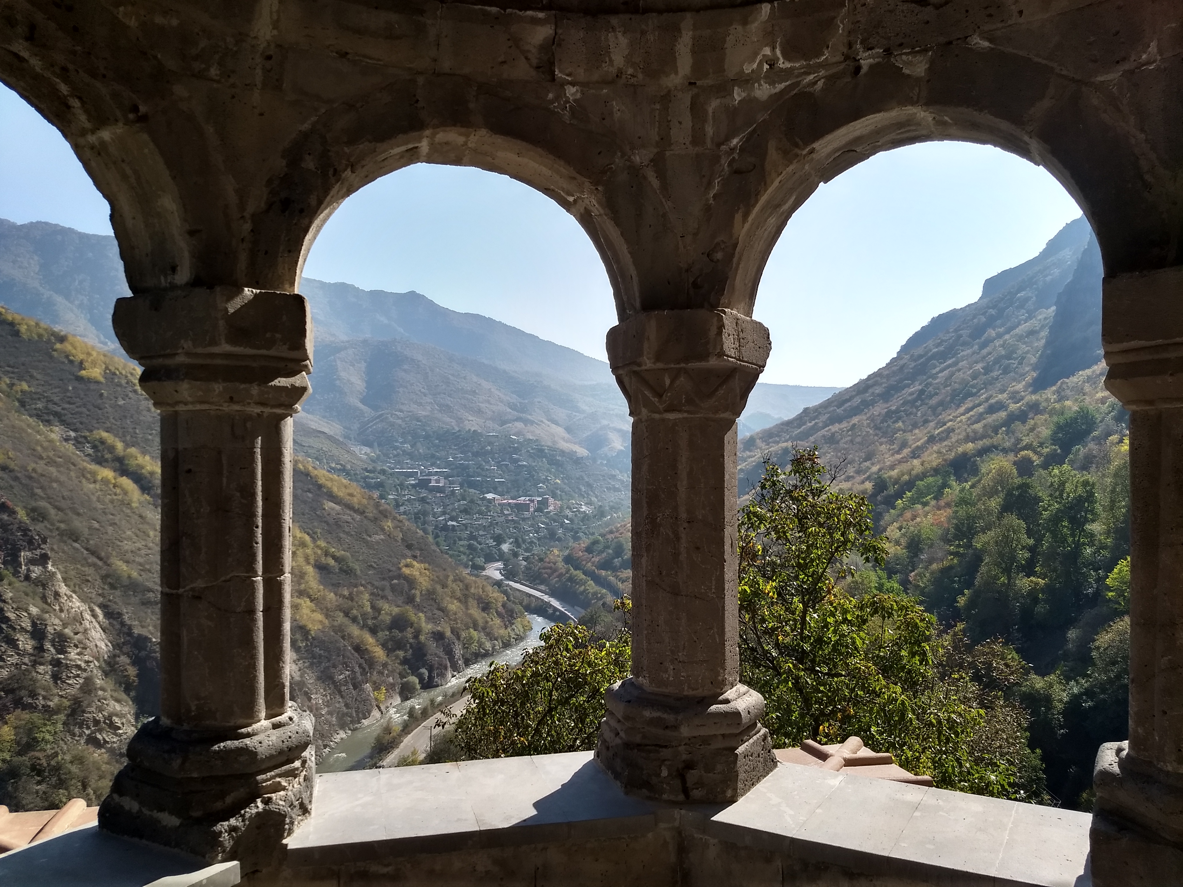 View through stone arches overlooking mountains and valley.