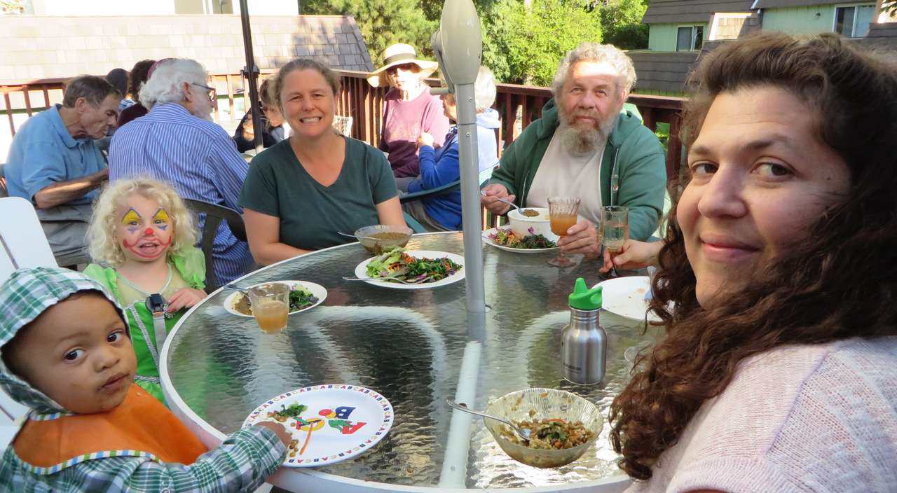 Group of diverse people enjoying outdoor meal at New Brighton Cohousing.