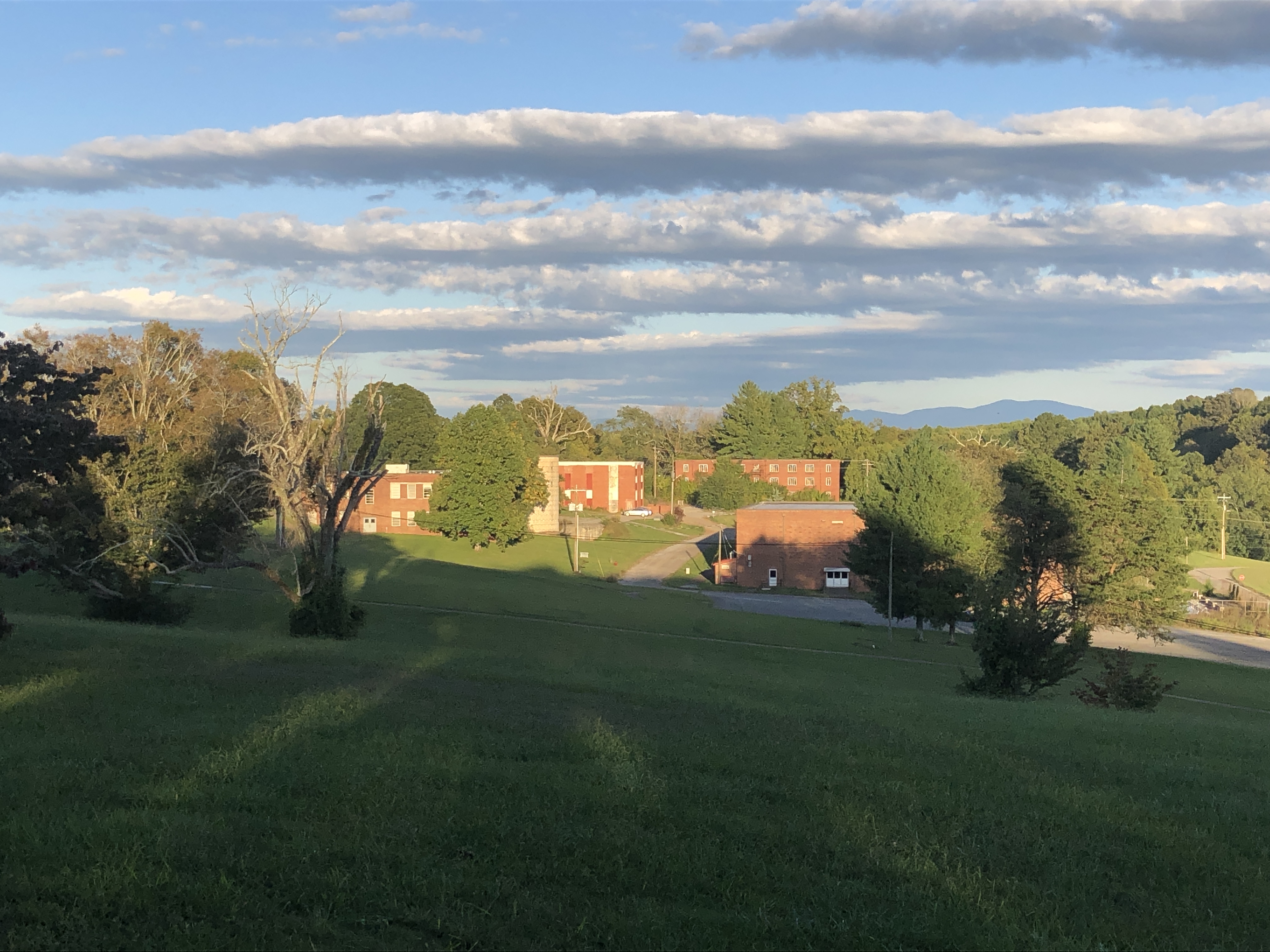 Scenic view of Hiwassee Bruderhof Community with green fields and buildings.