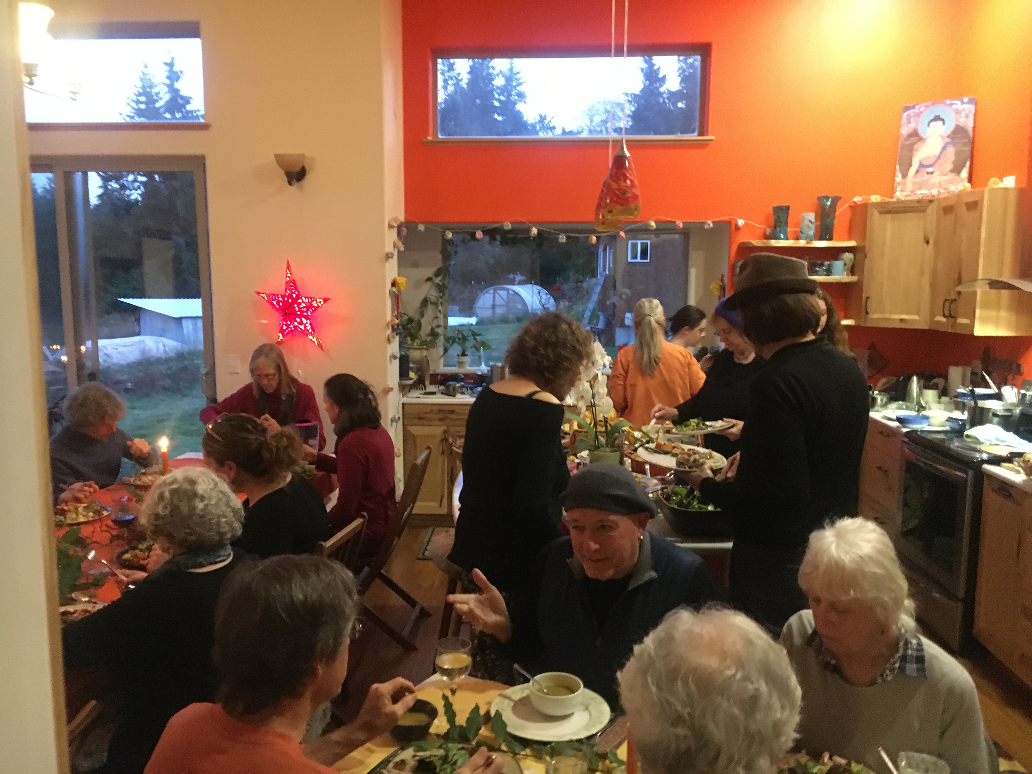 People gathered for a community meal in a cozy kitchen setting.