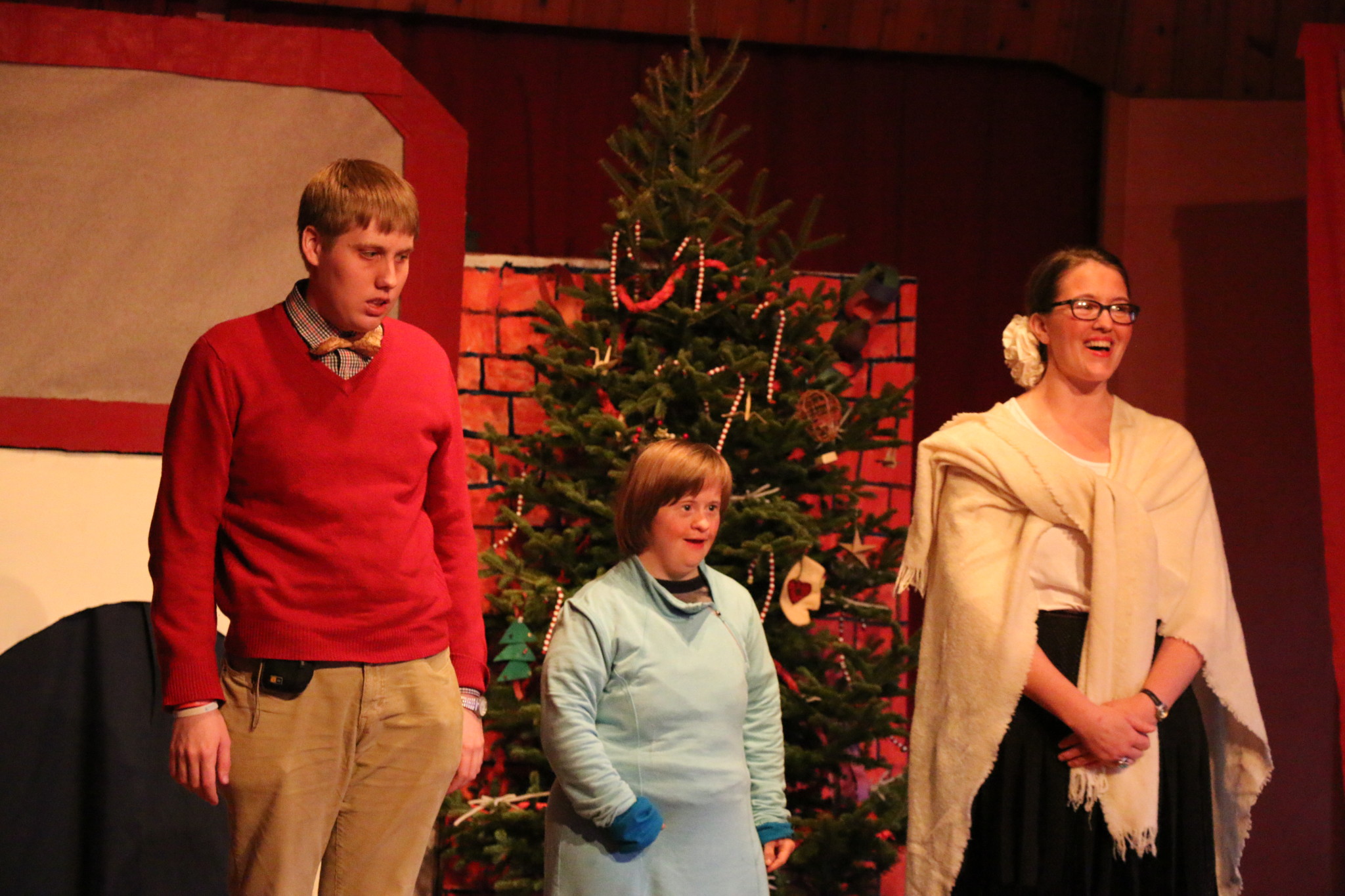 People celebrating around a decorated Christmas tree at Triform Camphill Community.