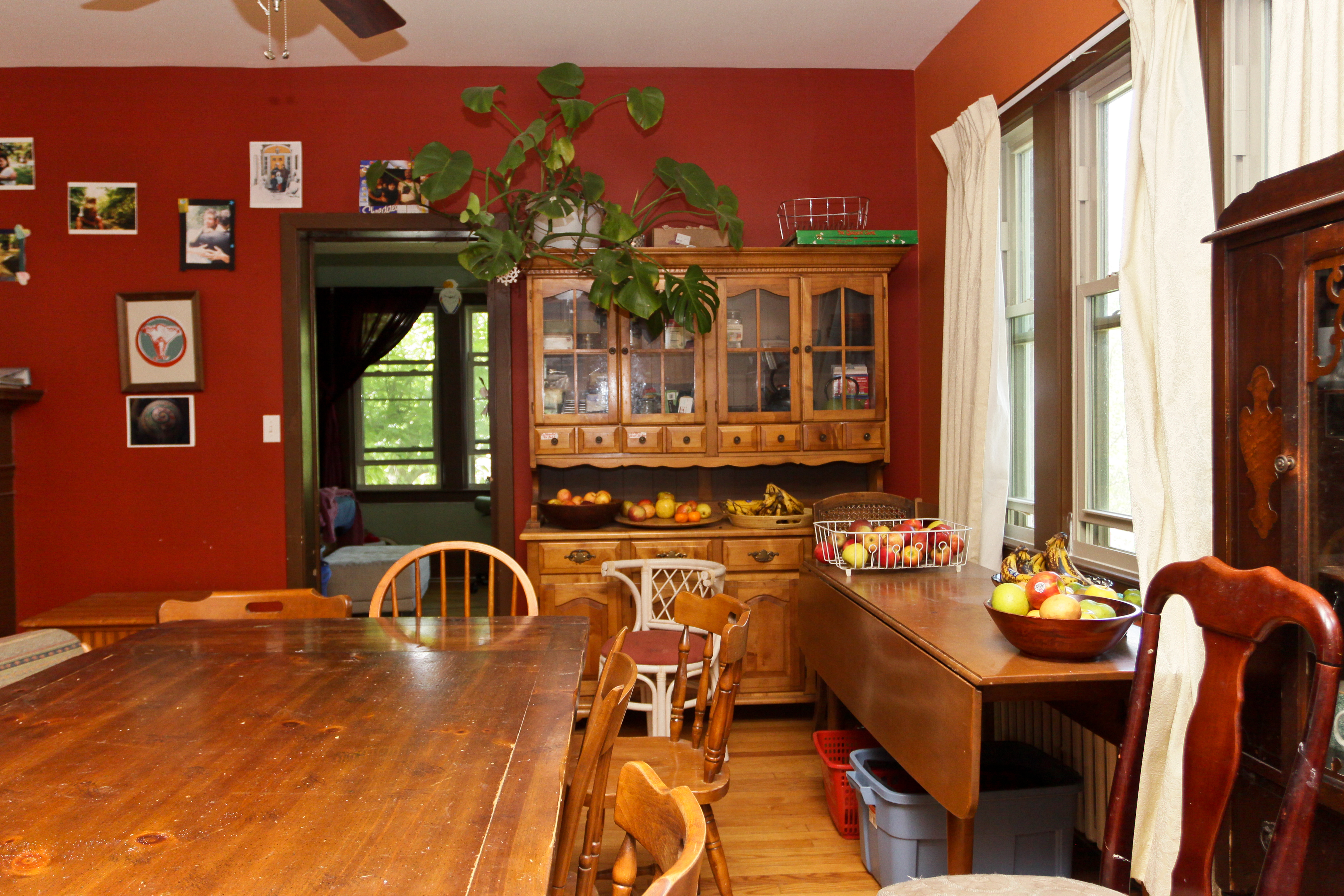 Interior of a warm, inviting dining room with wooden furniture and large windows.