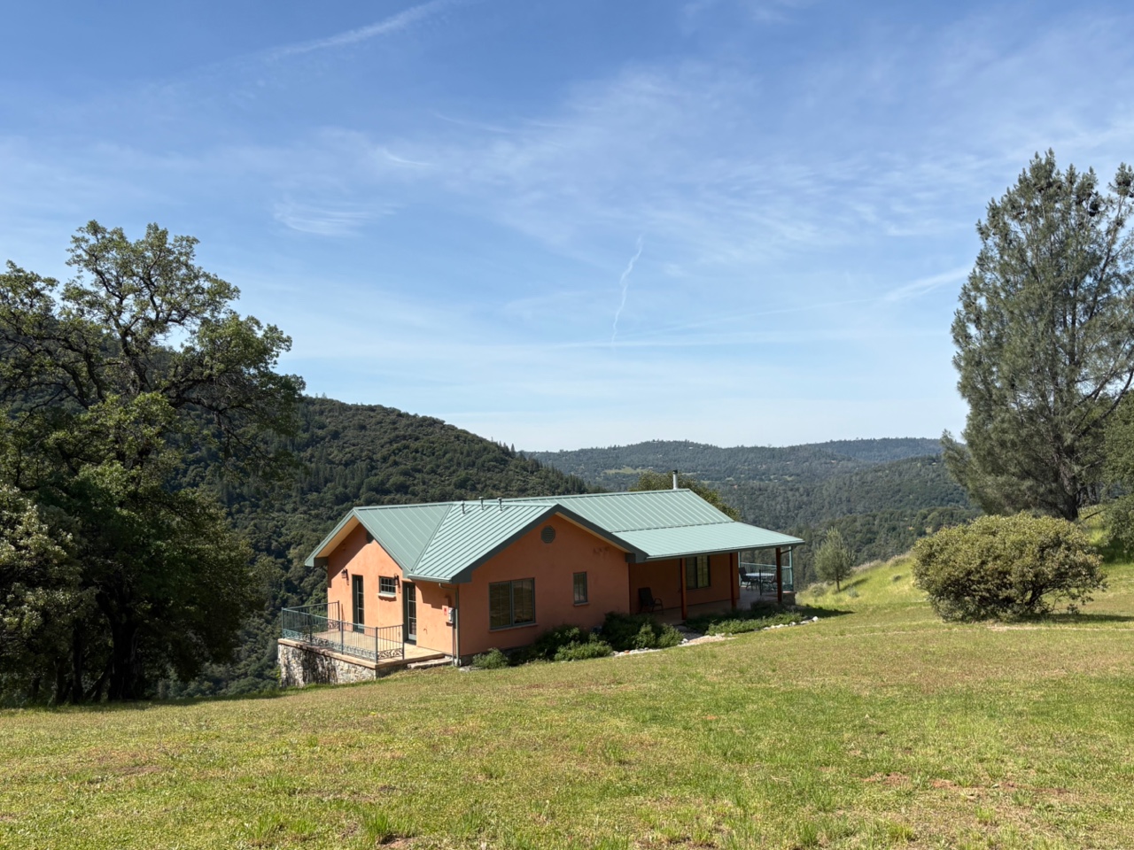 Eco-friendly house in a scenic rural landscape with hills and trees.