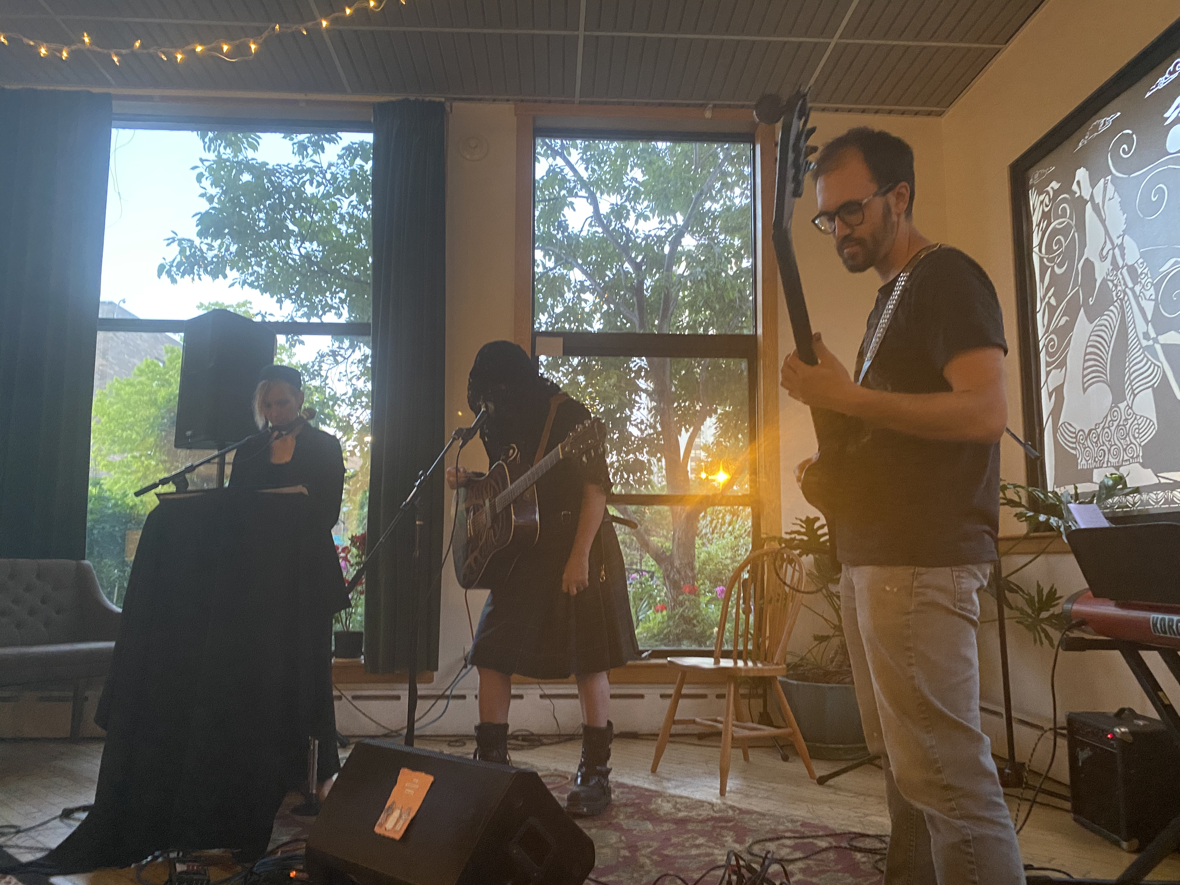 Musicians performing live music at a community gathering in a cozy indoor space.