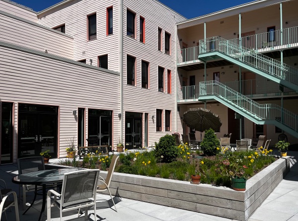 Community housing with outdoor garden and seating area.