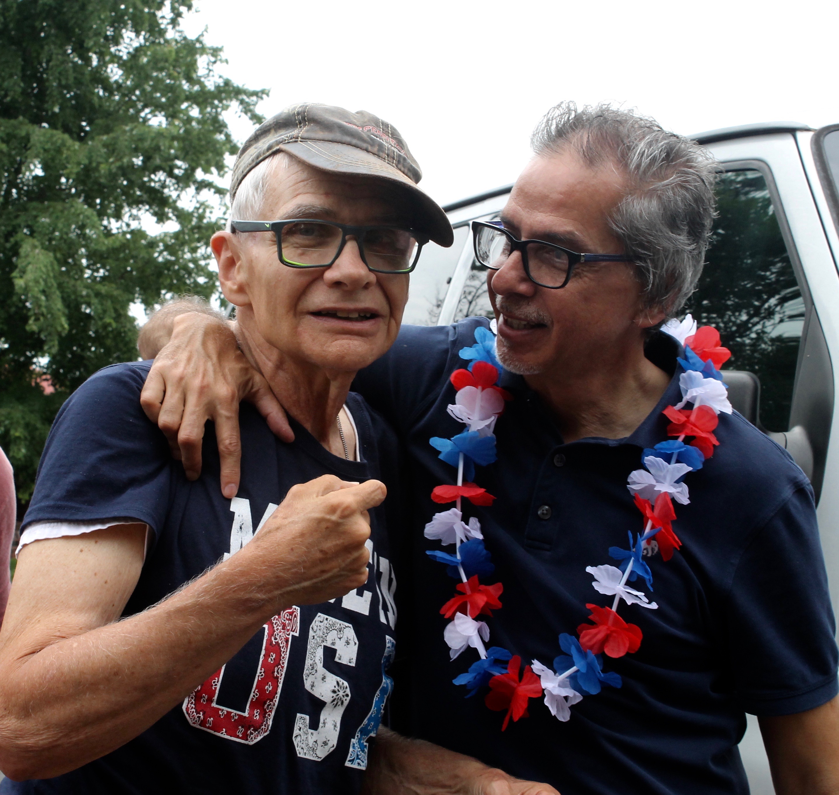 Two people celebrating at Innisfree Village with leis and smiles.