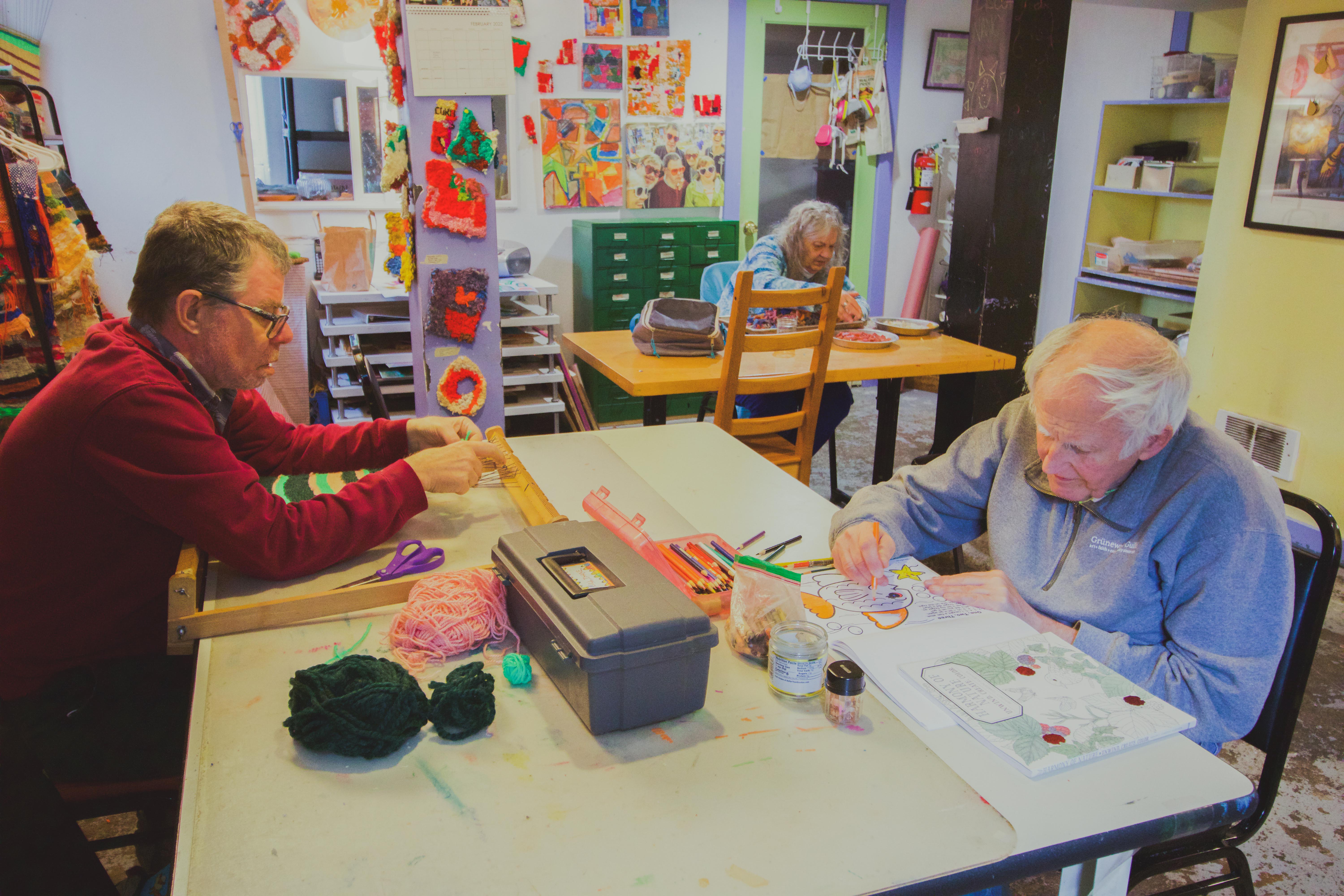 Elderly individuals engaging in arts and crafts at L'Arche Seattle.