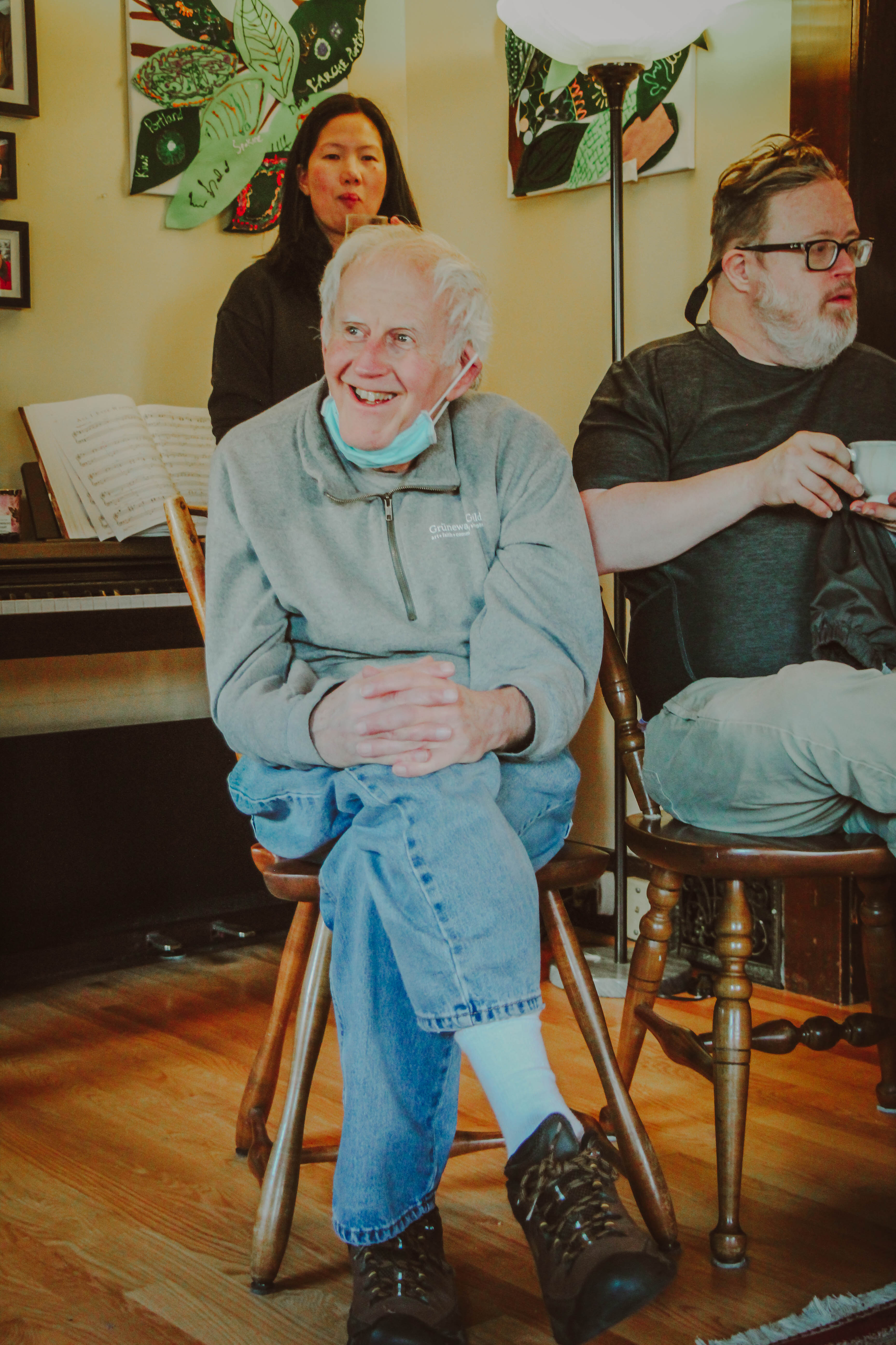 People enjoying a community event at L'Arche Seattle with smiles and conversation.