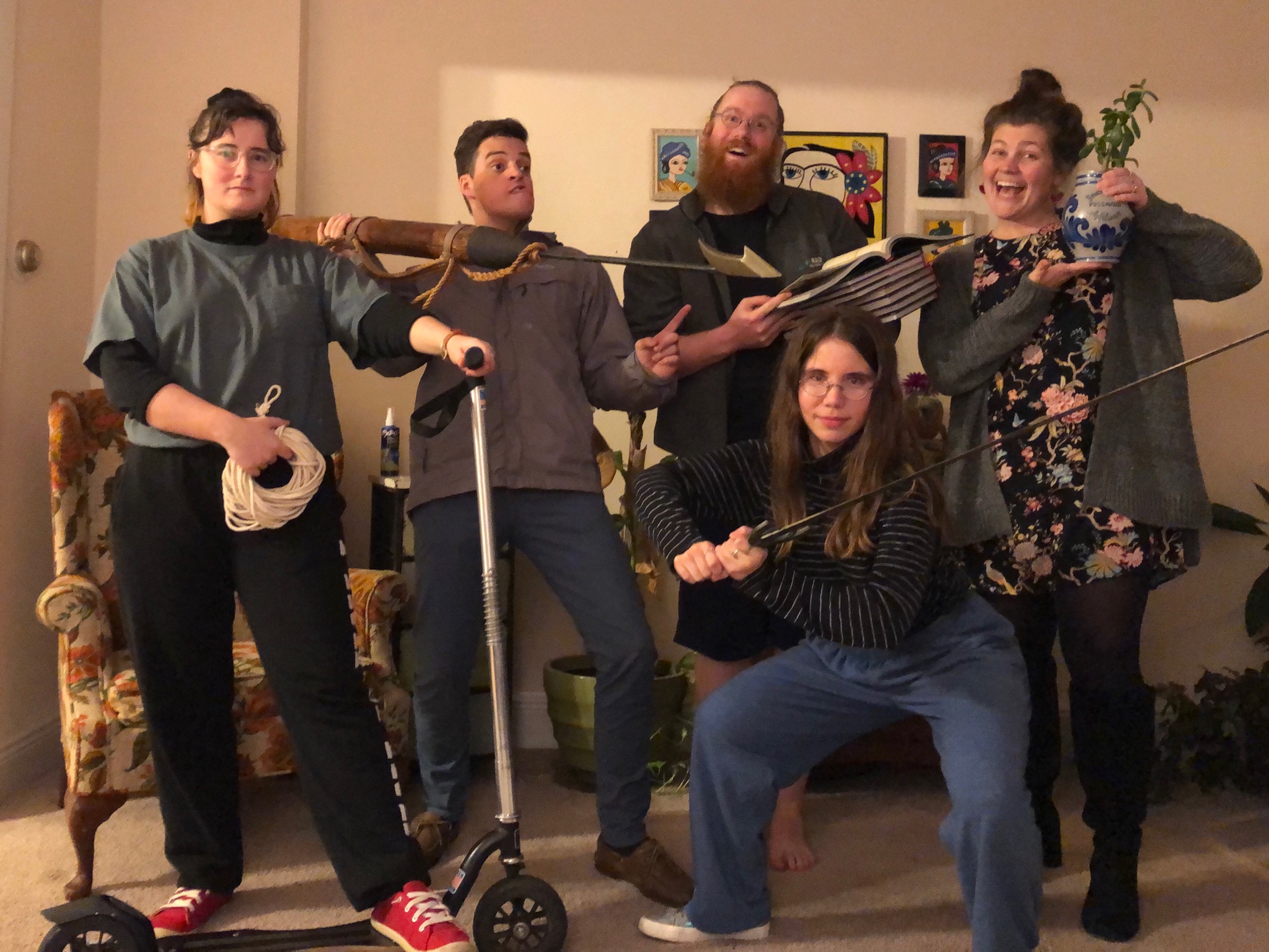 Group of five people with playful props in a living room.