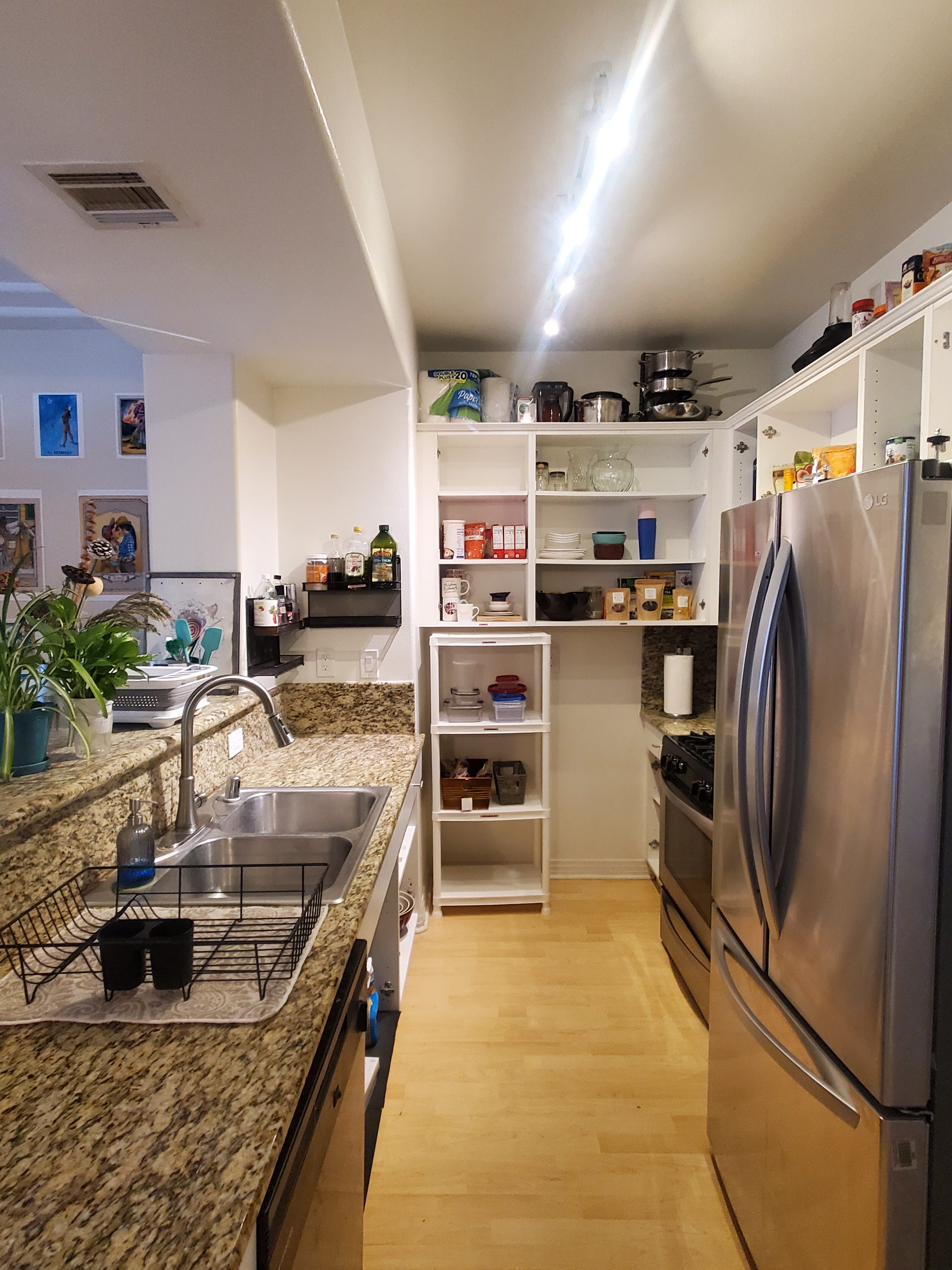 Modern kitchen with stainless steel appliances and open shelving near Los Angeles beach.