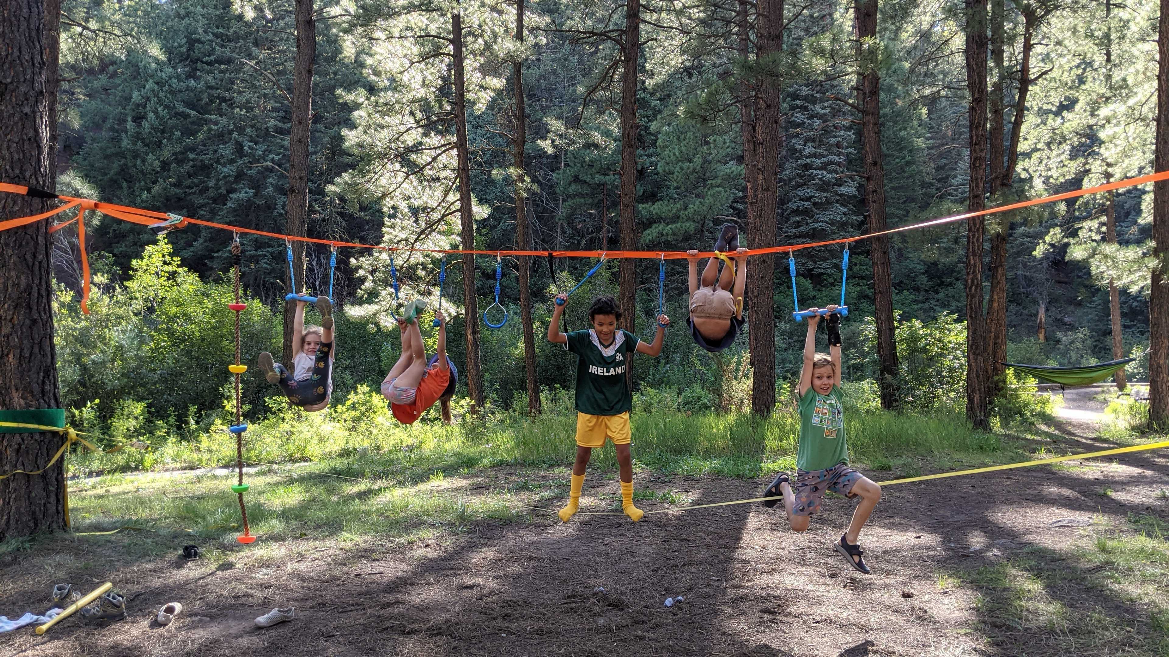 Kids enjoying outdoor play area with swings and climbing equipment.