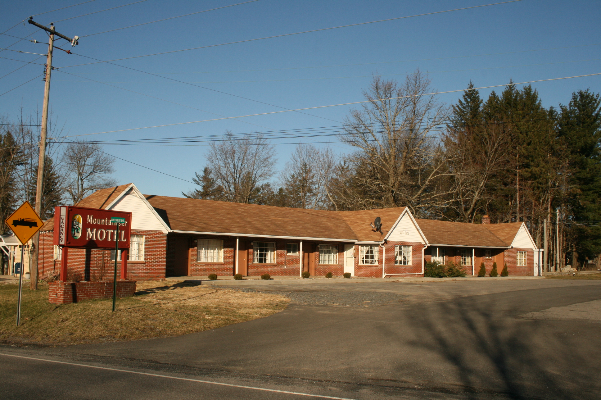 Rural Mountaineer Motel with brick building and trees in the background.