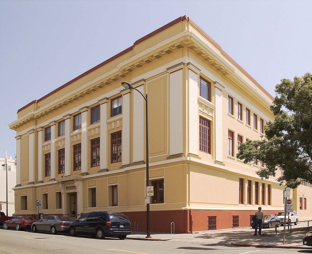 Historic yellow building with large windows and decorative architectural details.