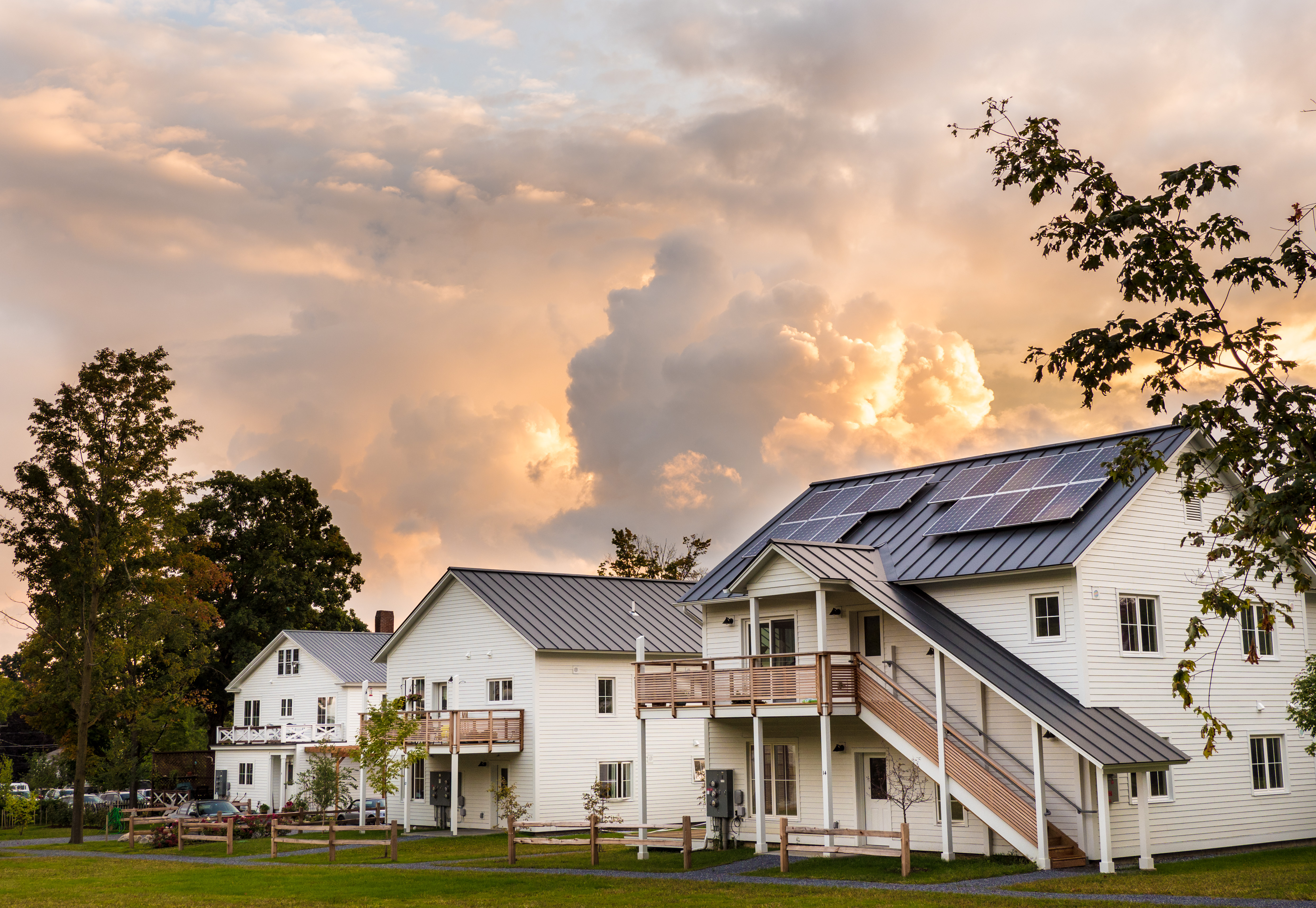 Modern cohousing homes with solar panels and green space.