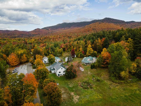 Scenic view of a community surrounded by colorful fall foliage and mountains.