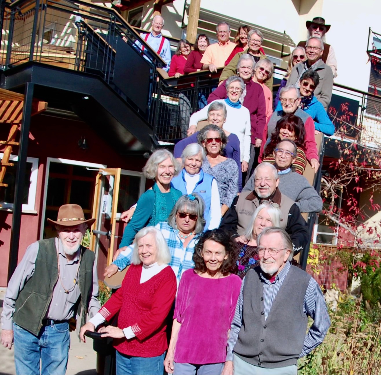 Group of diverse seniors gathered outdoors at Silver Sage Village for community event.